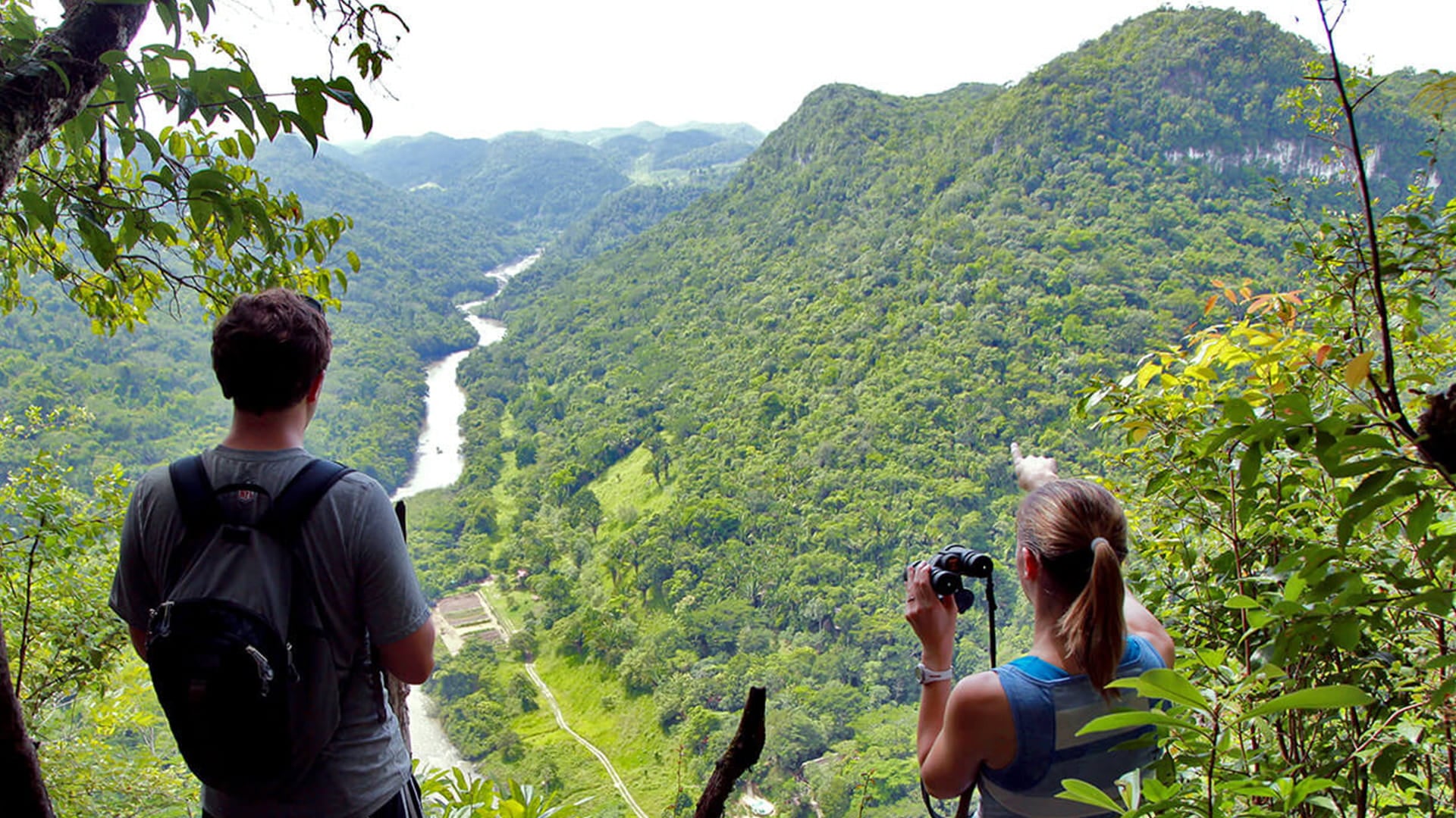 Two hikers looking out at the Macal River from above, Belize