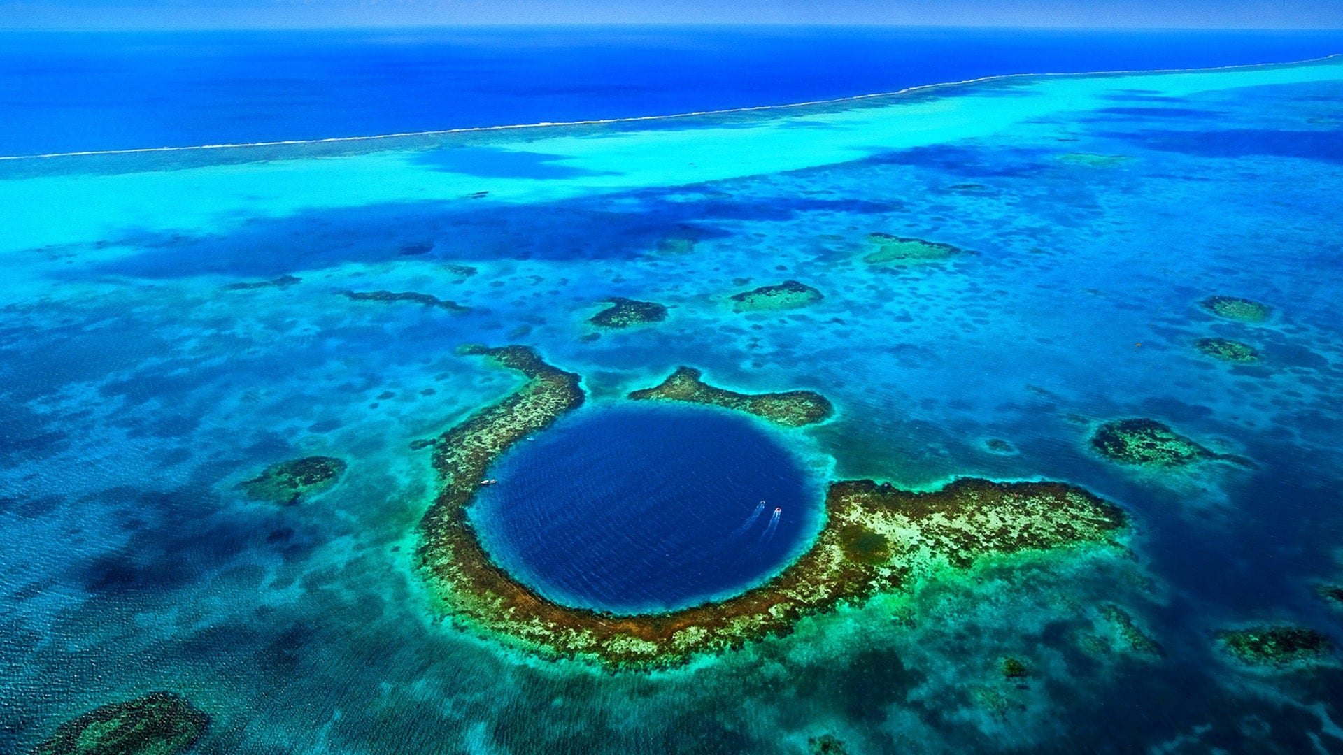 An overhead shot of two boats in the Great Blue Hole, Belize