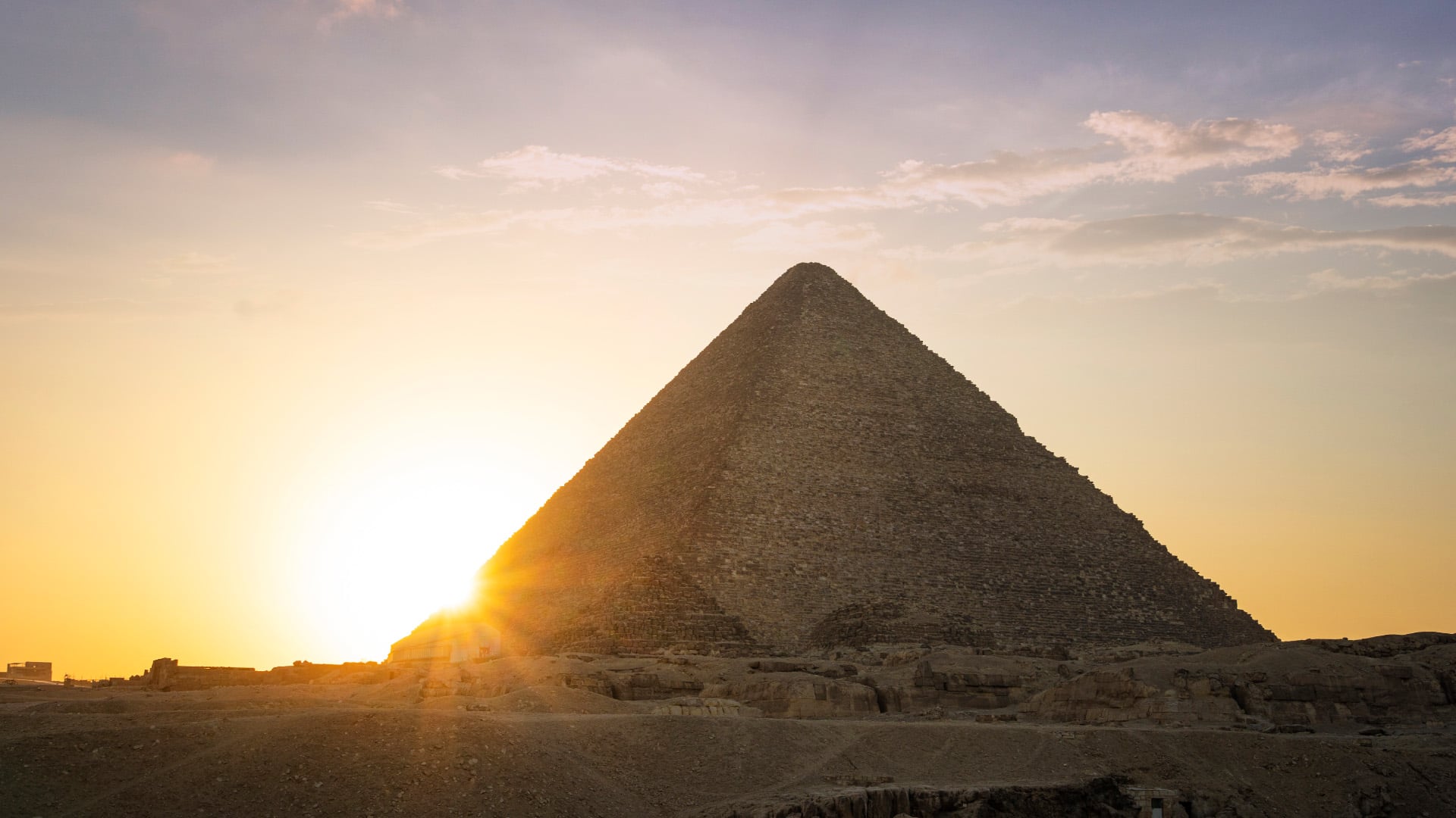 The sun disappears behind the Great Pyramid of Giza in Egypt.