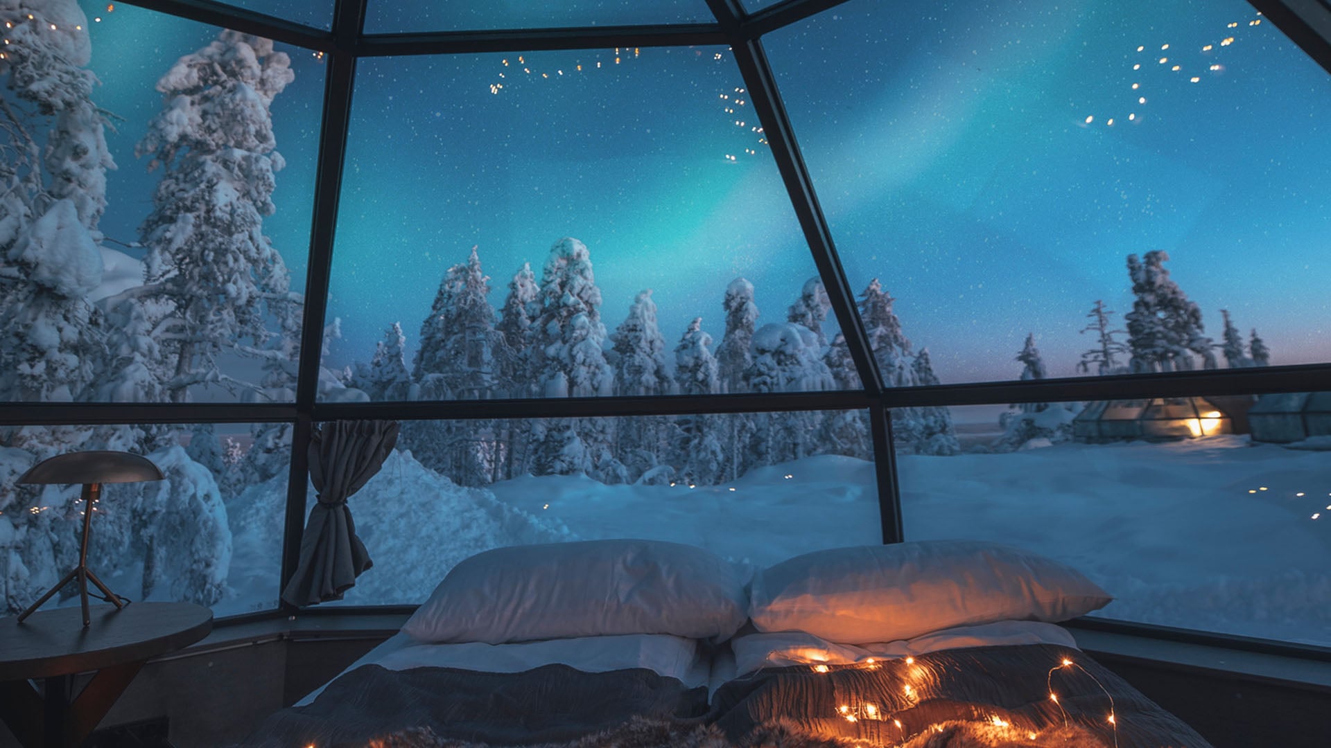 View of the Northern Lights from inside a glass igloo at a resort in Finland