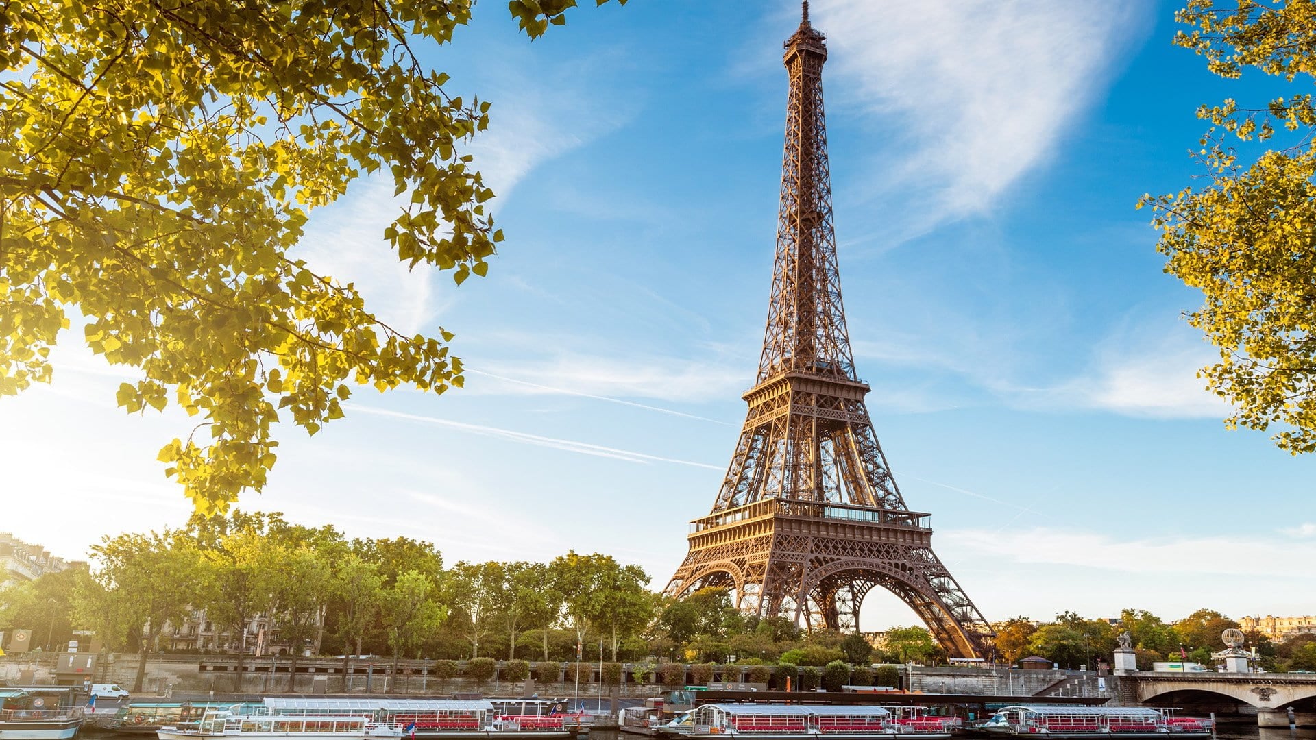 iron tower alongside a river with blue sky