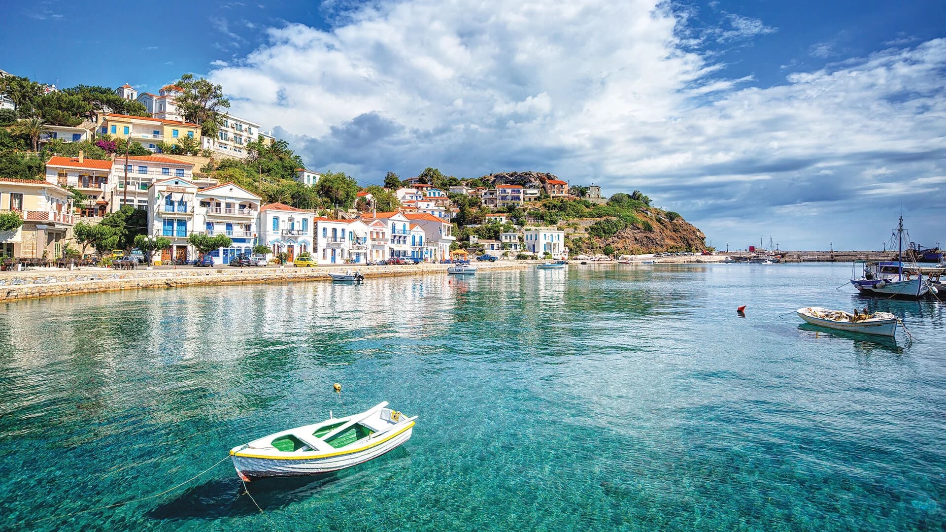 Boats are anchored off the shore of a small town on the island of Ikaria, Greece.