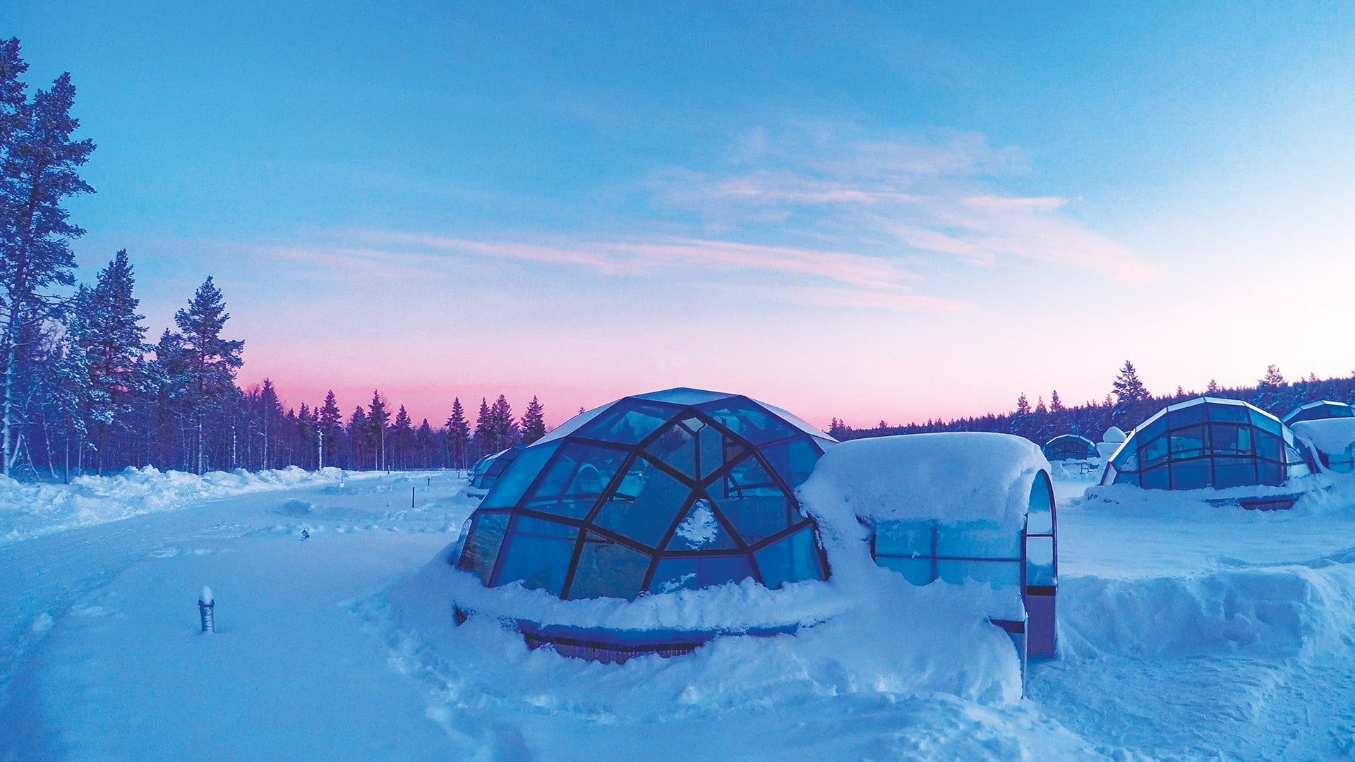 Glass igloos covered in snow in Finland