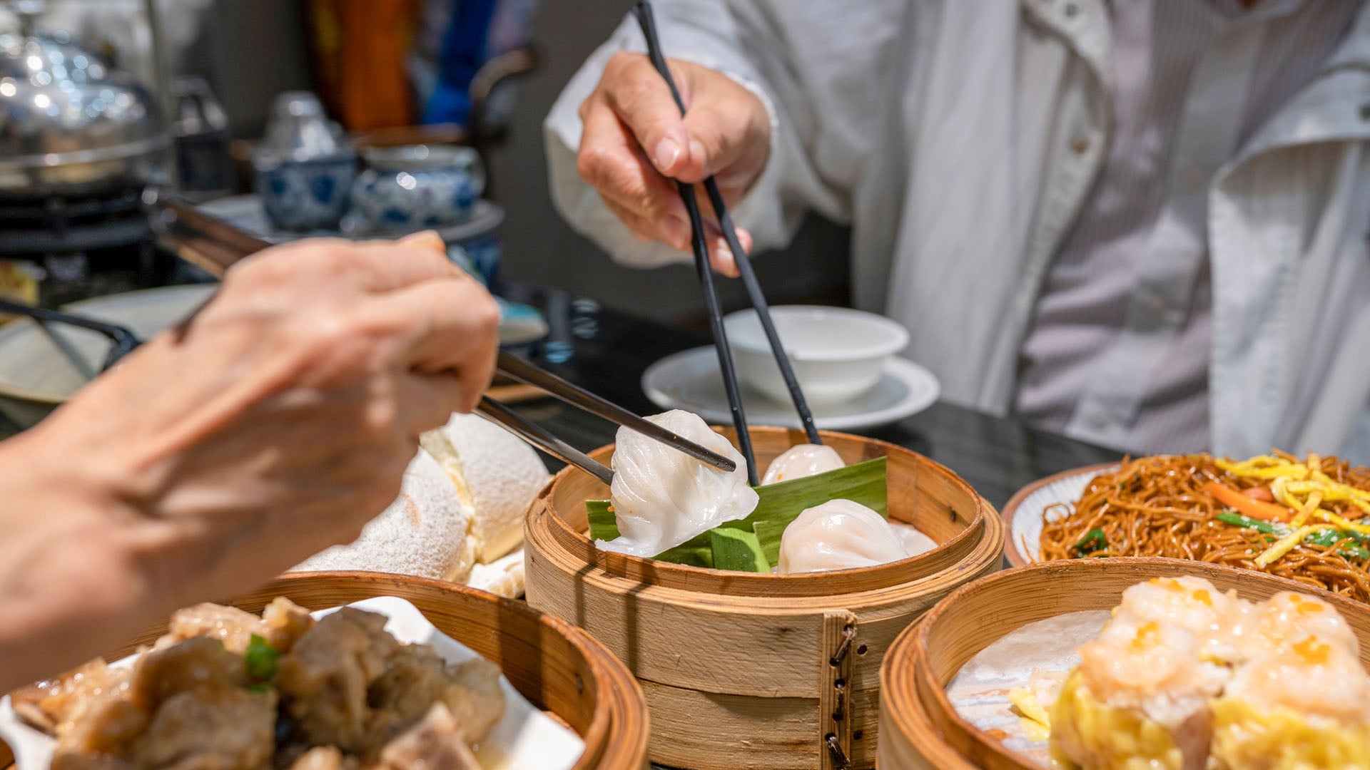 Two men eating dim sum in a restaurant in Hong Kong.