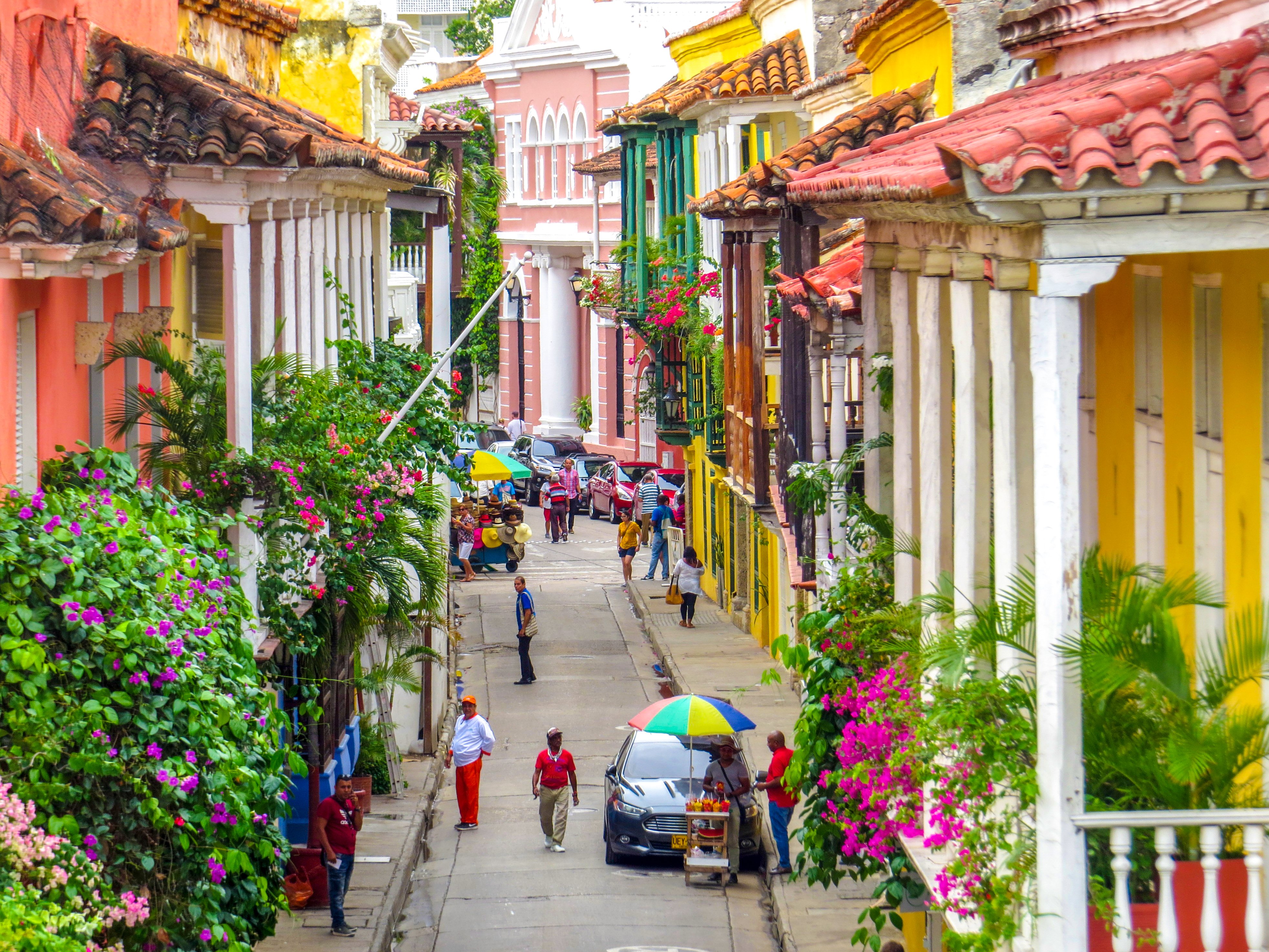 Street in walled city in Cartagena Colombia with people walking in the walled city and old town.