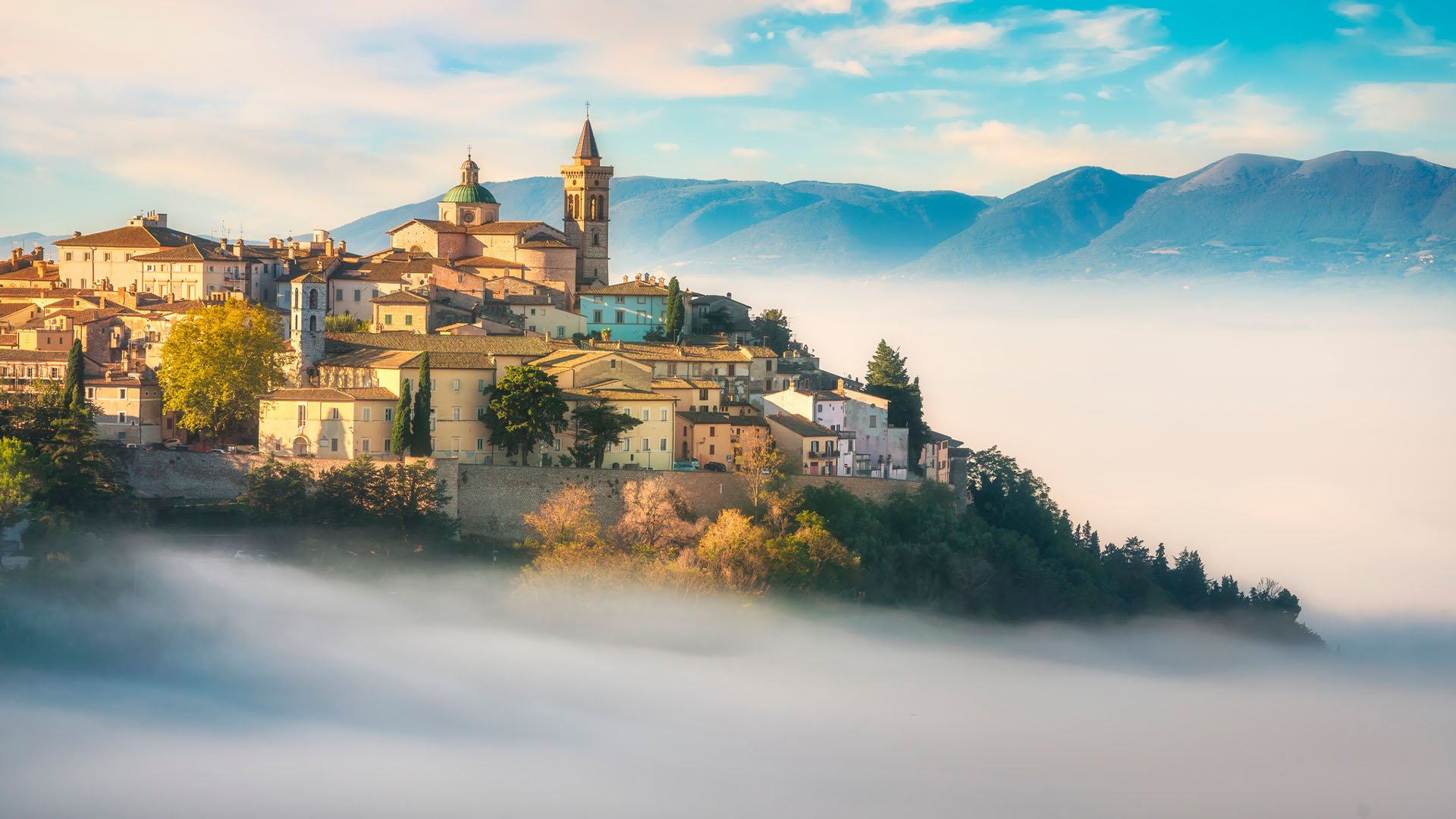 The town of Trevi draped in fog in the morning in Italy