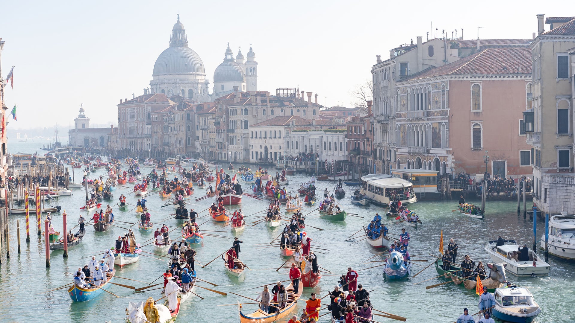 Gondolas go down the Grand Canal in Venice during the Venice Carnival in Italy