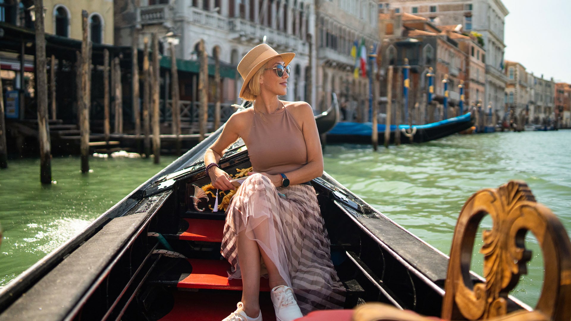 A solo woman traveller riding a gondola along the canals of Venice