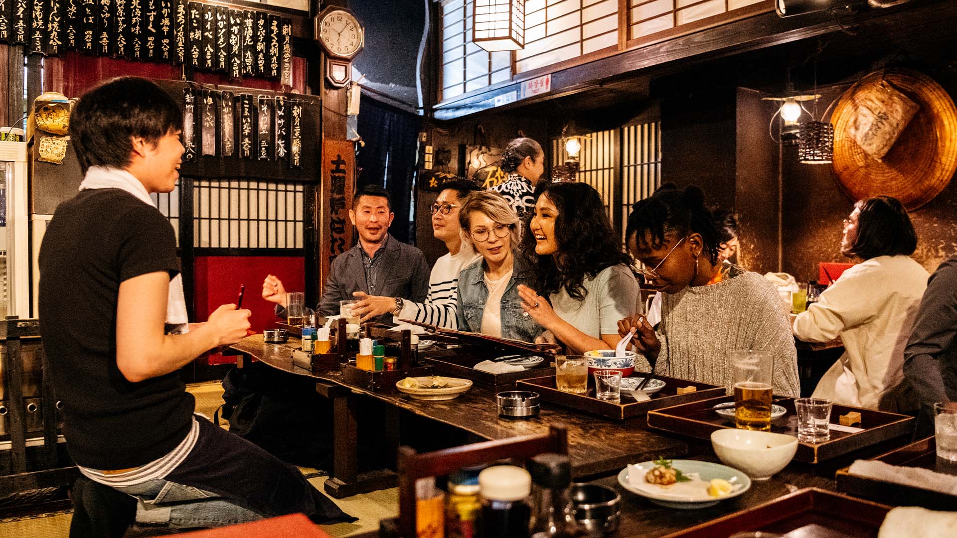 A group of foreigners dine in an izakaya in Tokyo, Japan
