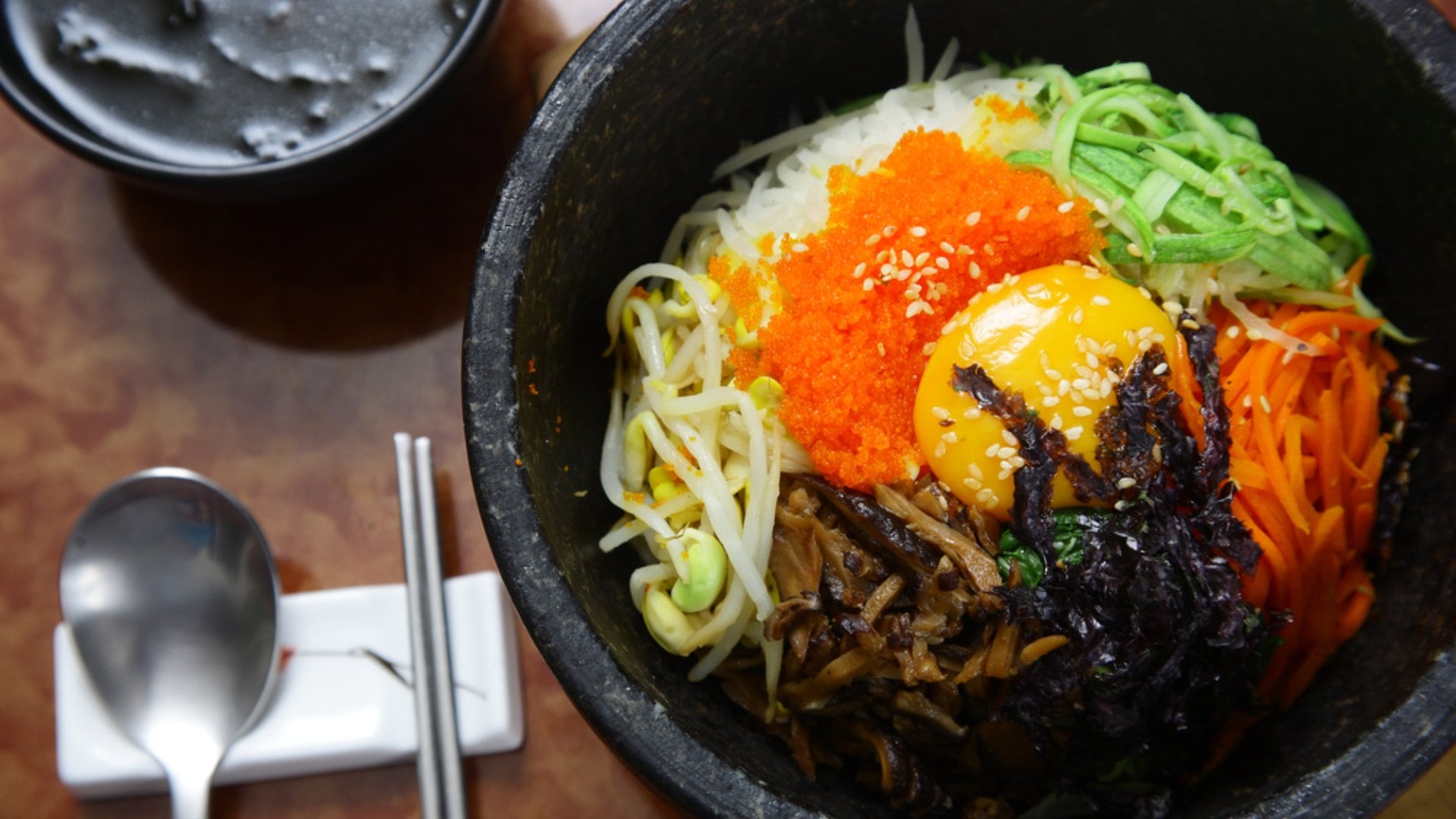 Korean cuisine : bibimbap in a heated stone bowl