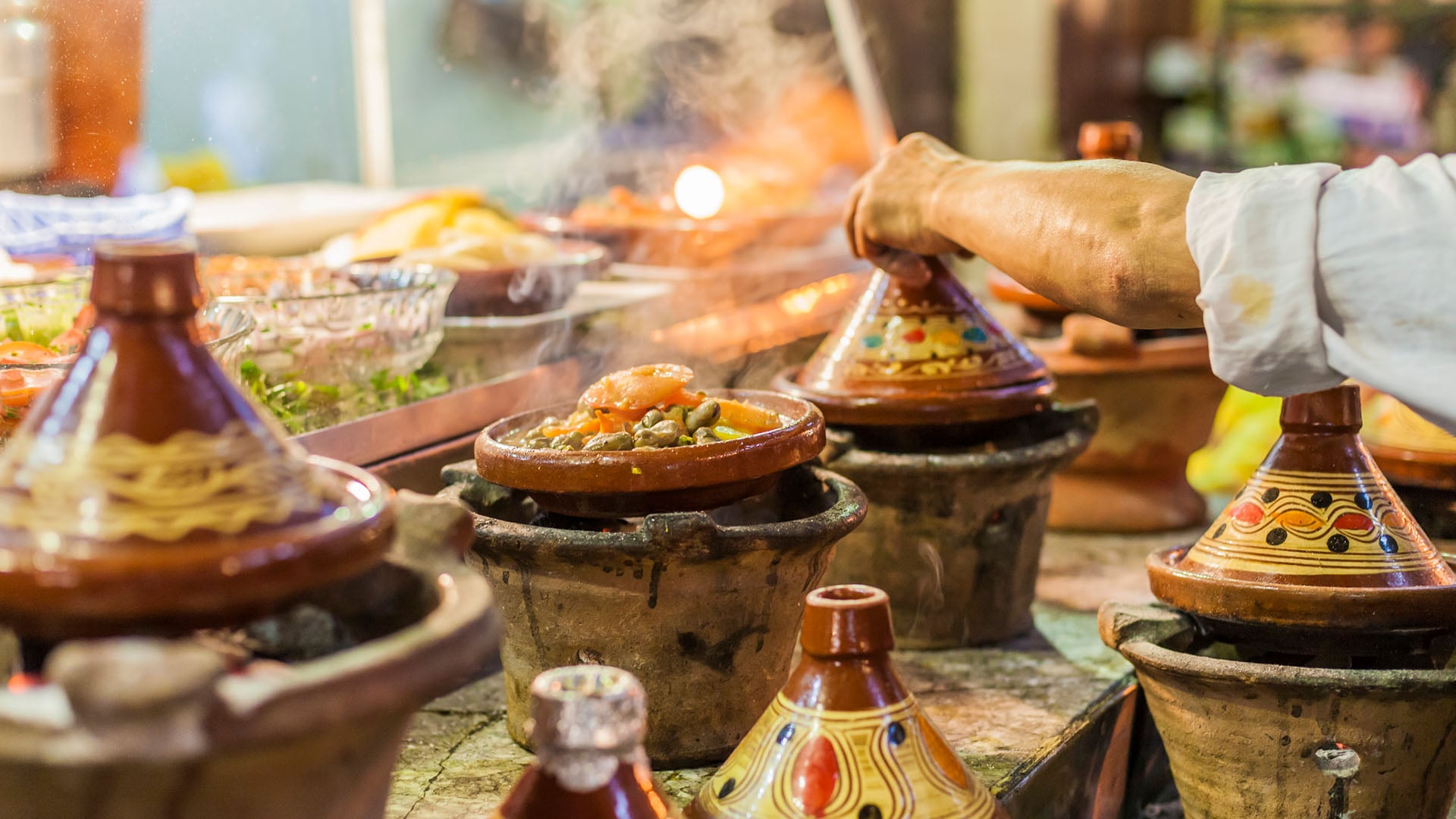 A man cooking a bunch of different tajines in Morocco