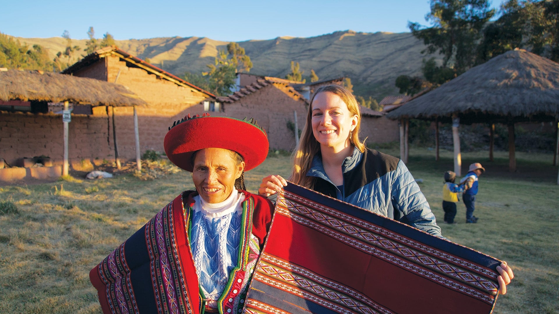 Heather holding high-quality textiles next to a local weaver