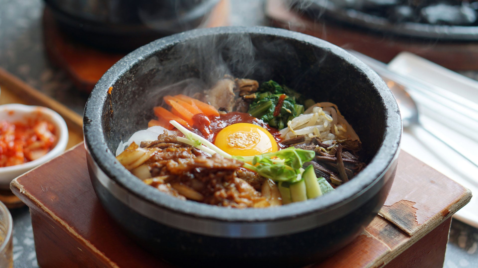 Dolsot bibimbap - Korean mixed rice, Include steamed rice, vegetables, pork and fried egg on top, served in a hot stone pot
