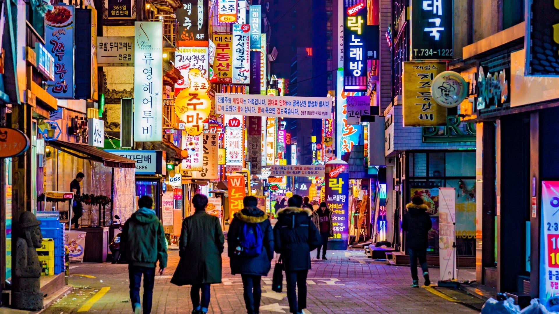 People walking in downtown Seoul, South Korea, at night.