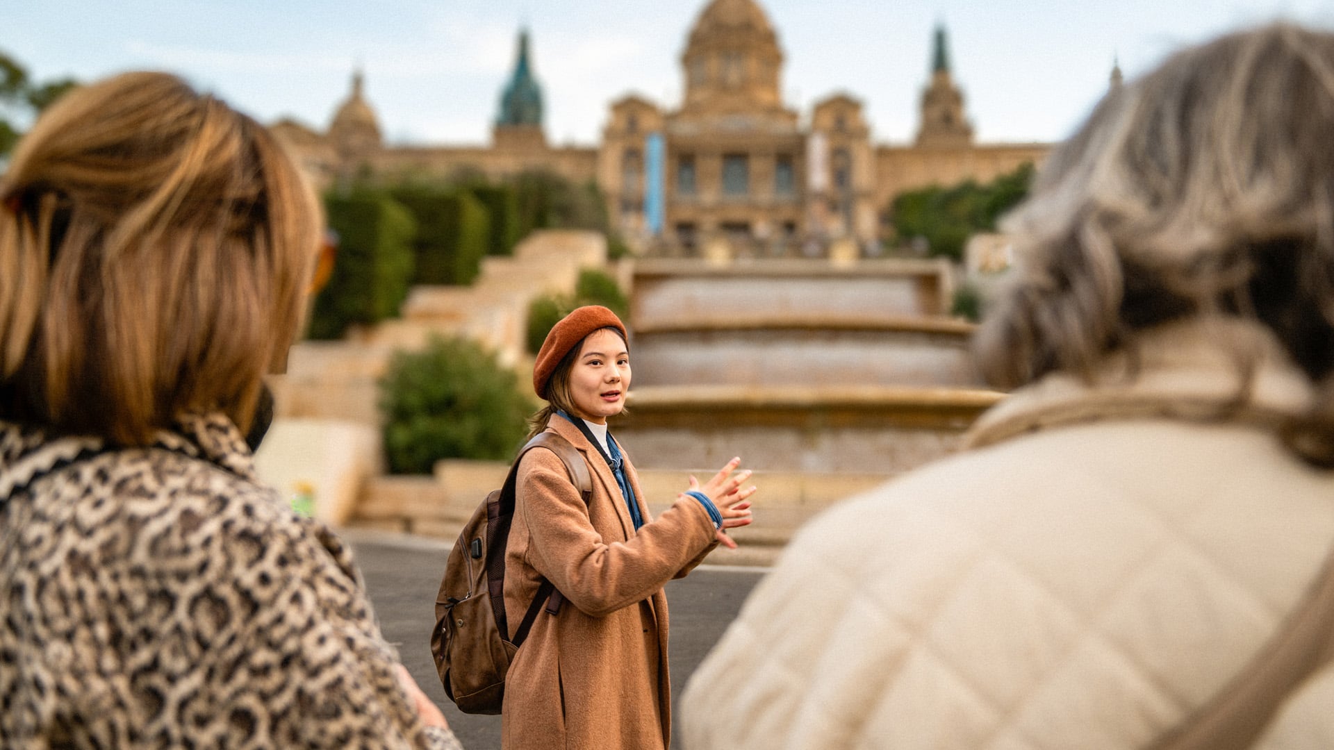 A tour guide leads a group of women around a historic landmark in Spain