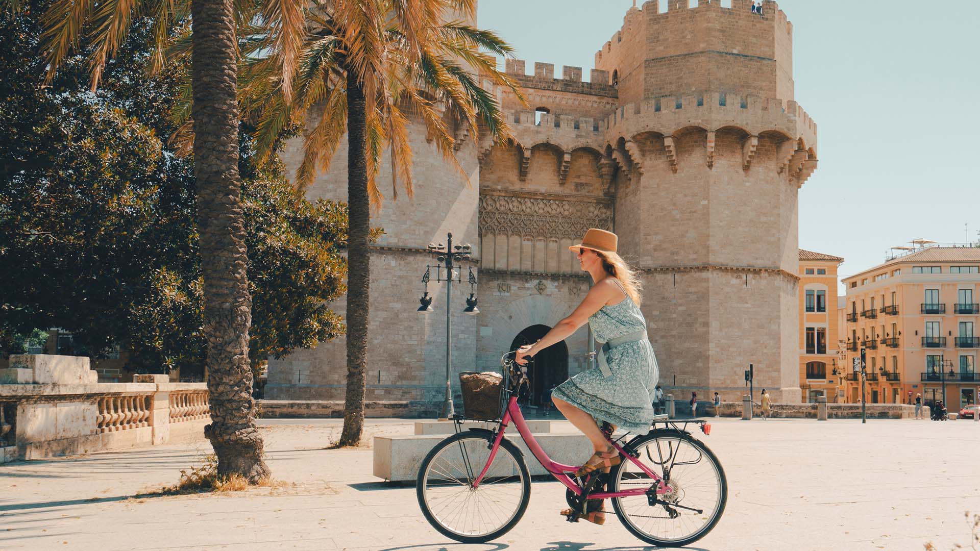 A woman cycling in front of an old fort in the Spanish city of Valencia