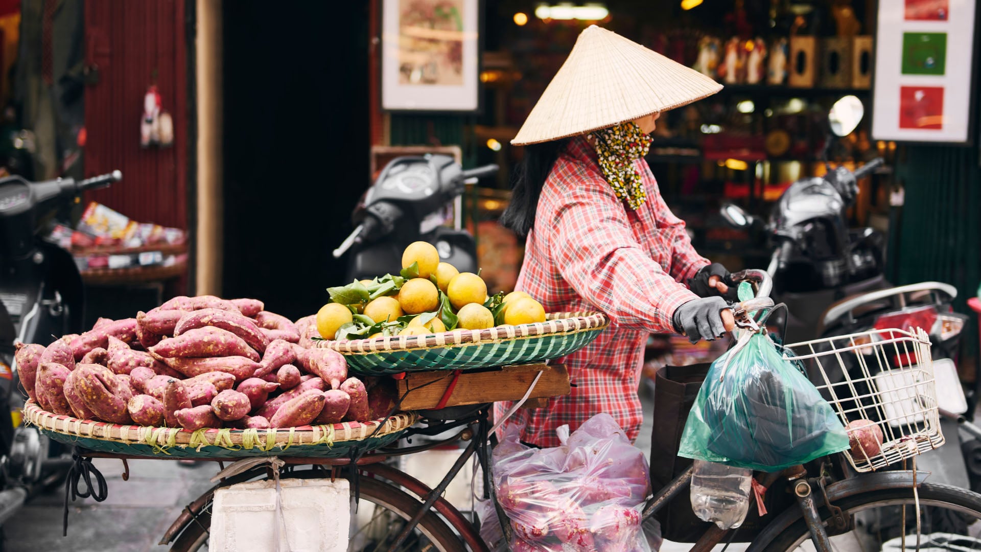 A woman hauling fruit and vegetables in a market in Hanoi, Vietnam