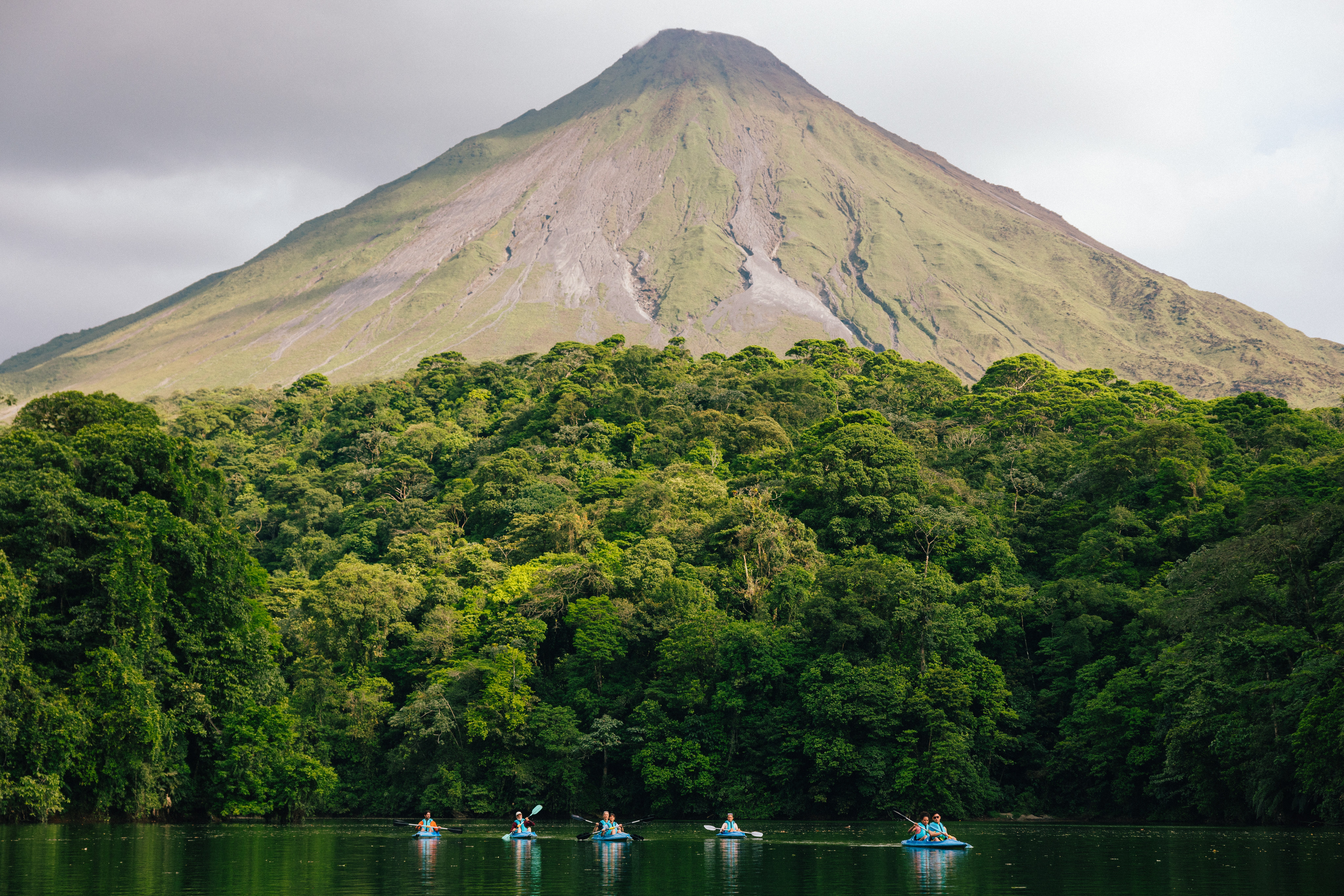 Sea kayakers in front of Arenal volcano, Costa Rica.