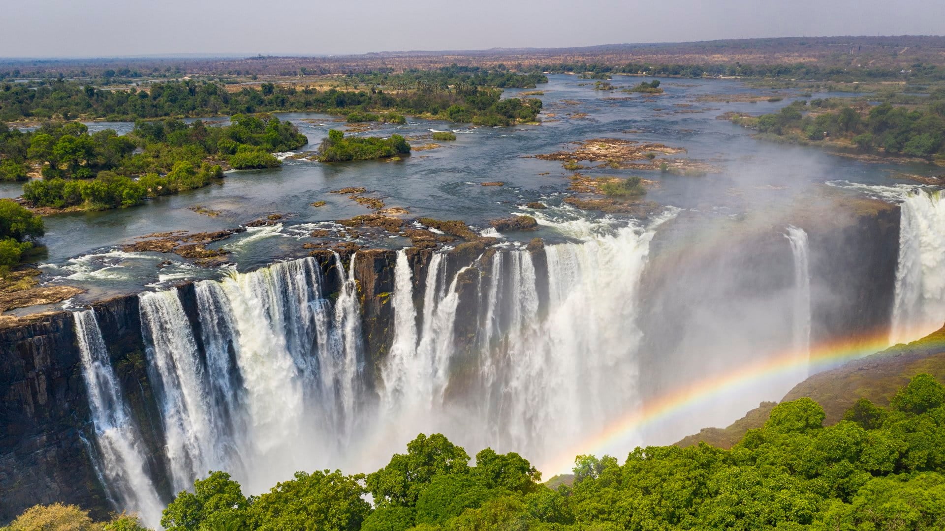 Aerial few of the world famous Victoria Falls with a large rainbow over the falls.