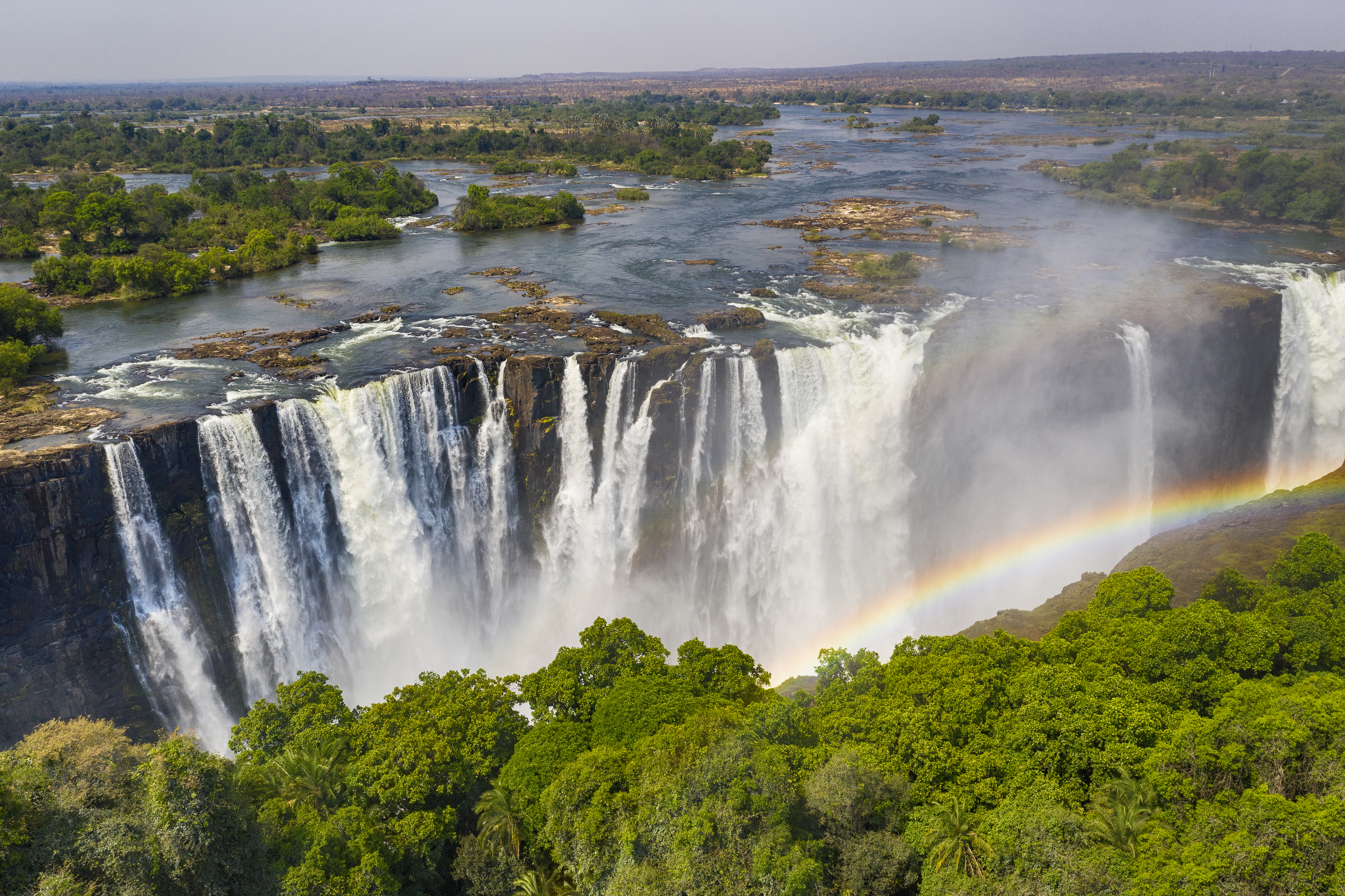 Aerial few of the world famous Victoria Falls with a large rainbow over the falls.