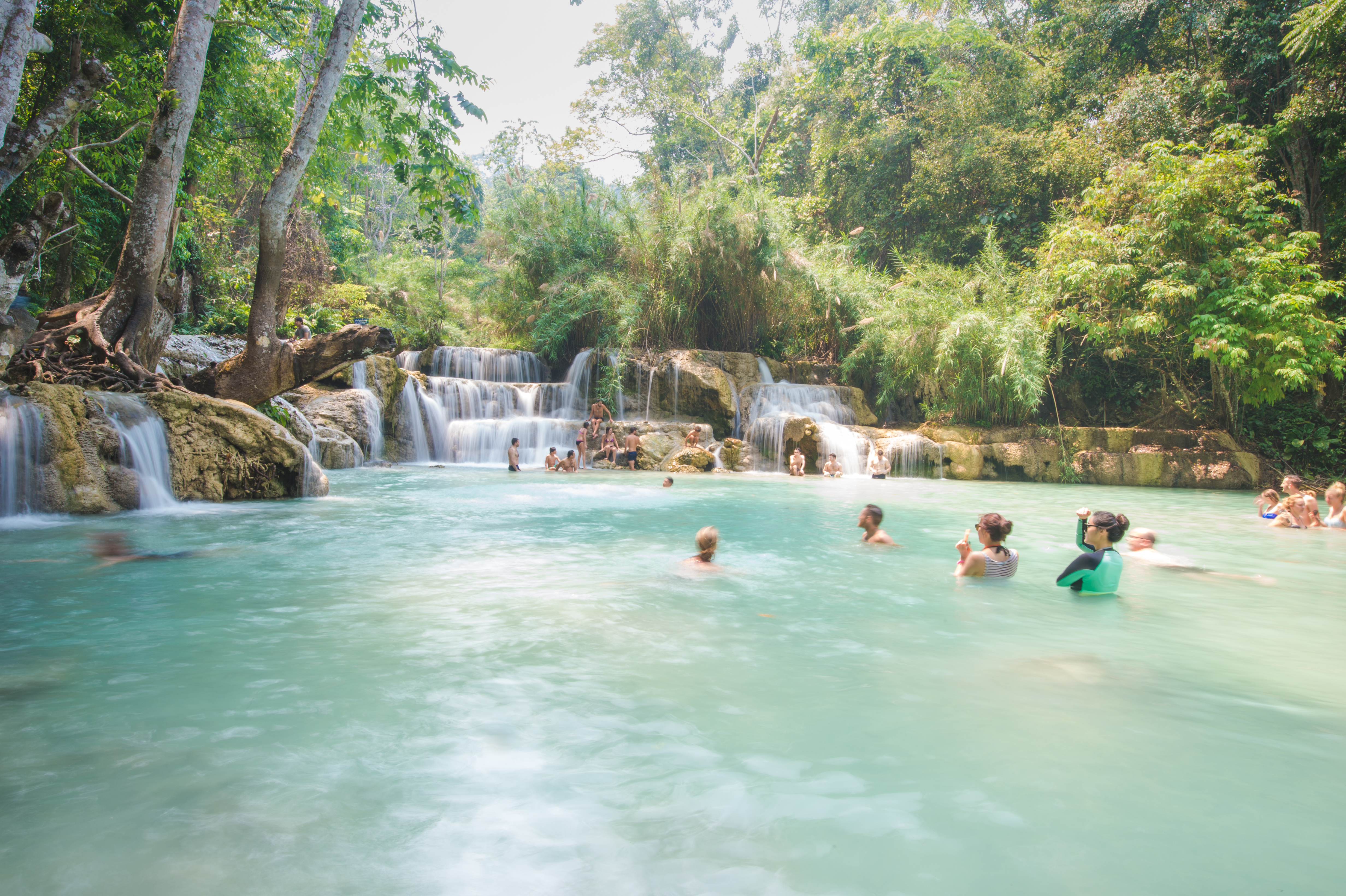 Tourists swimming by the waterfall
