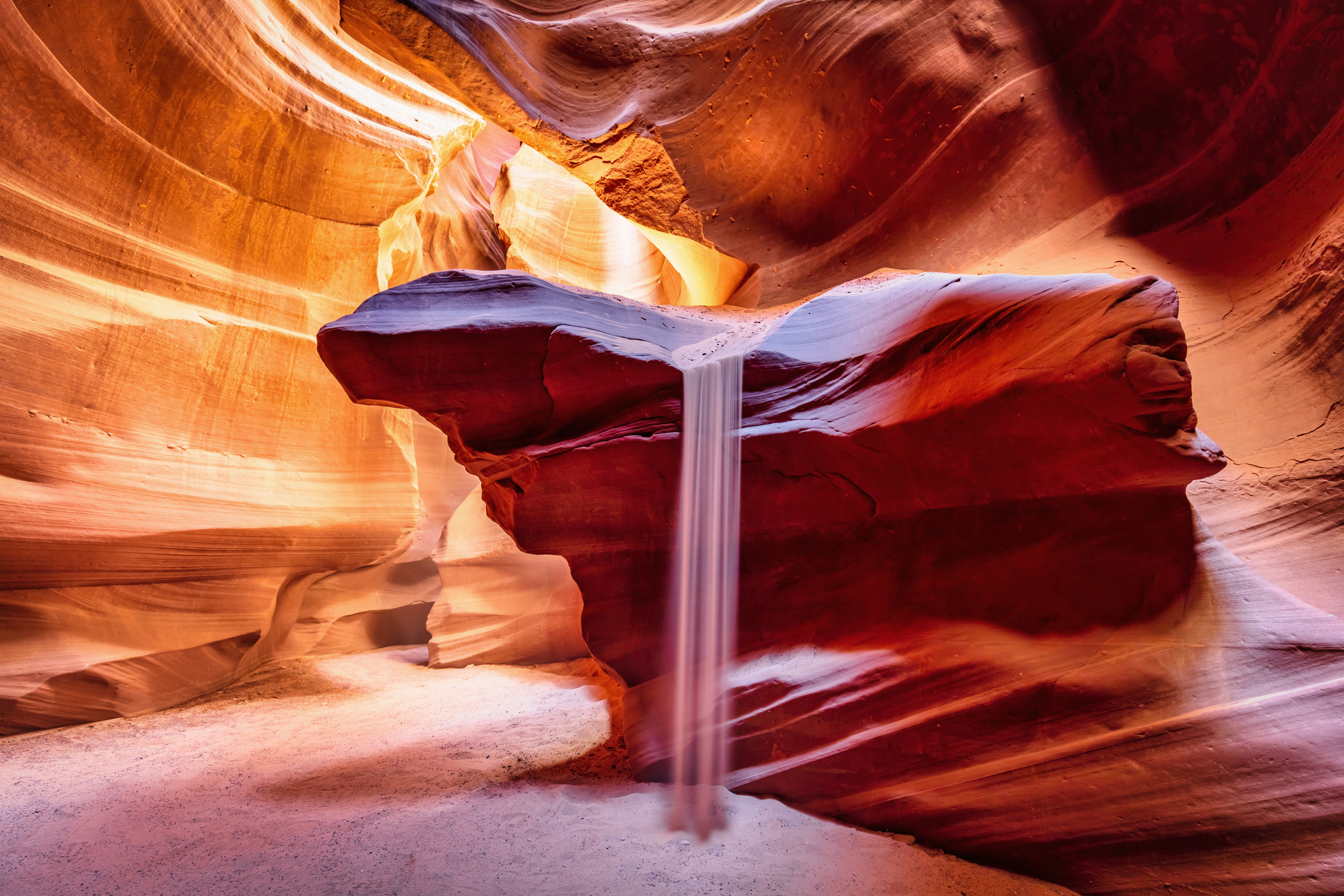 Sandfall, beautiful natural phenomenon inside the majestic Antelope Canyon in early morning light.