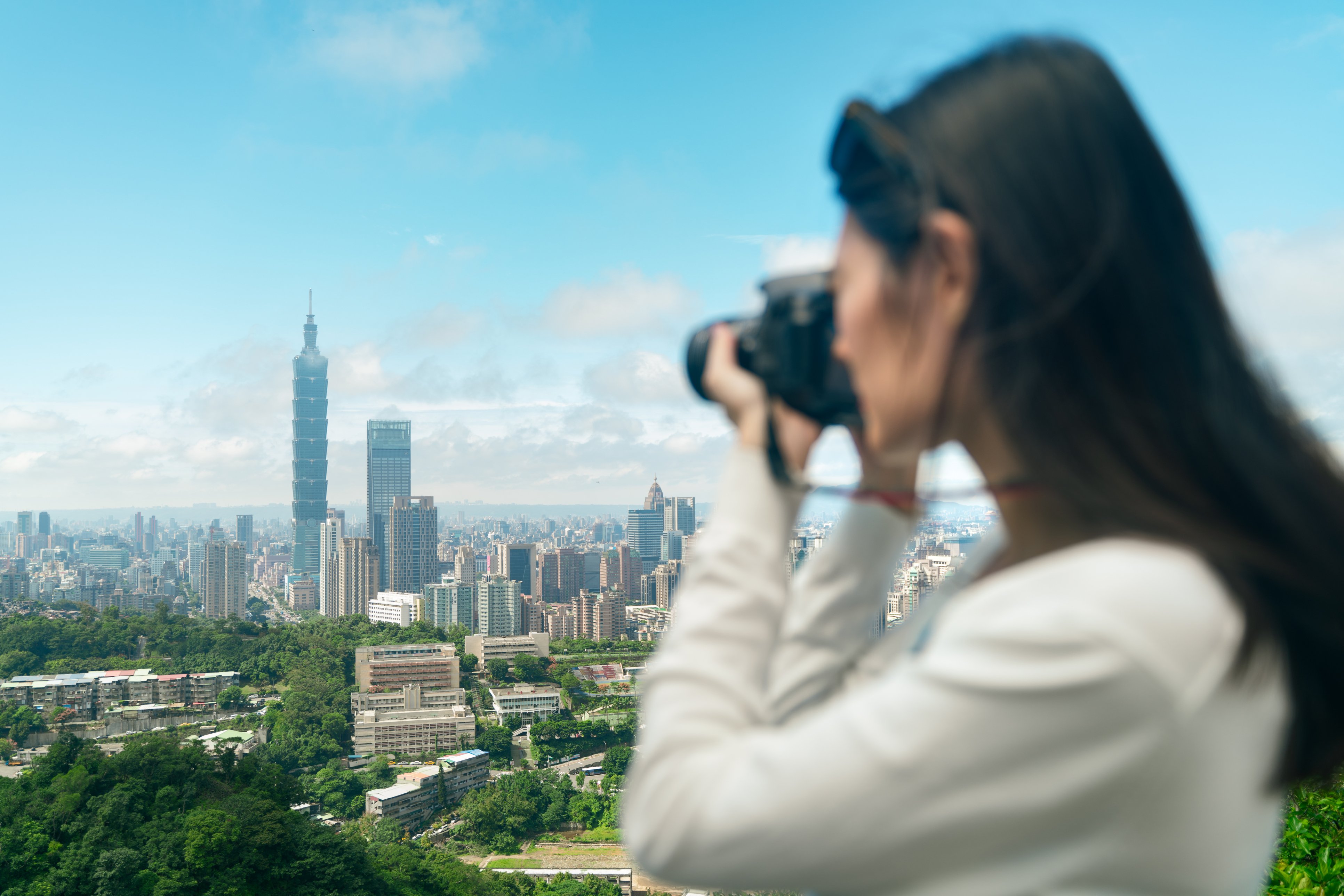 Traveler taking photos of among skyscrapers