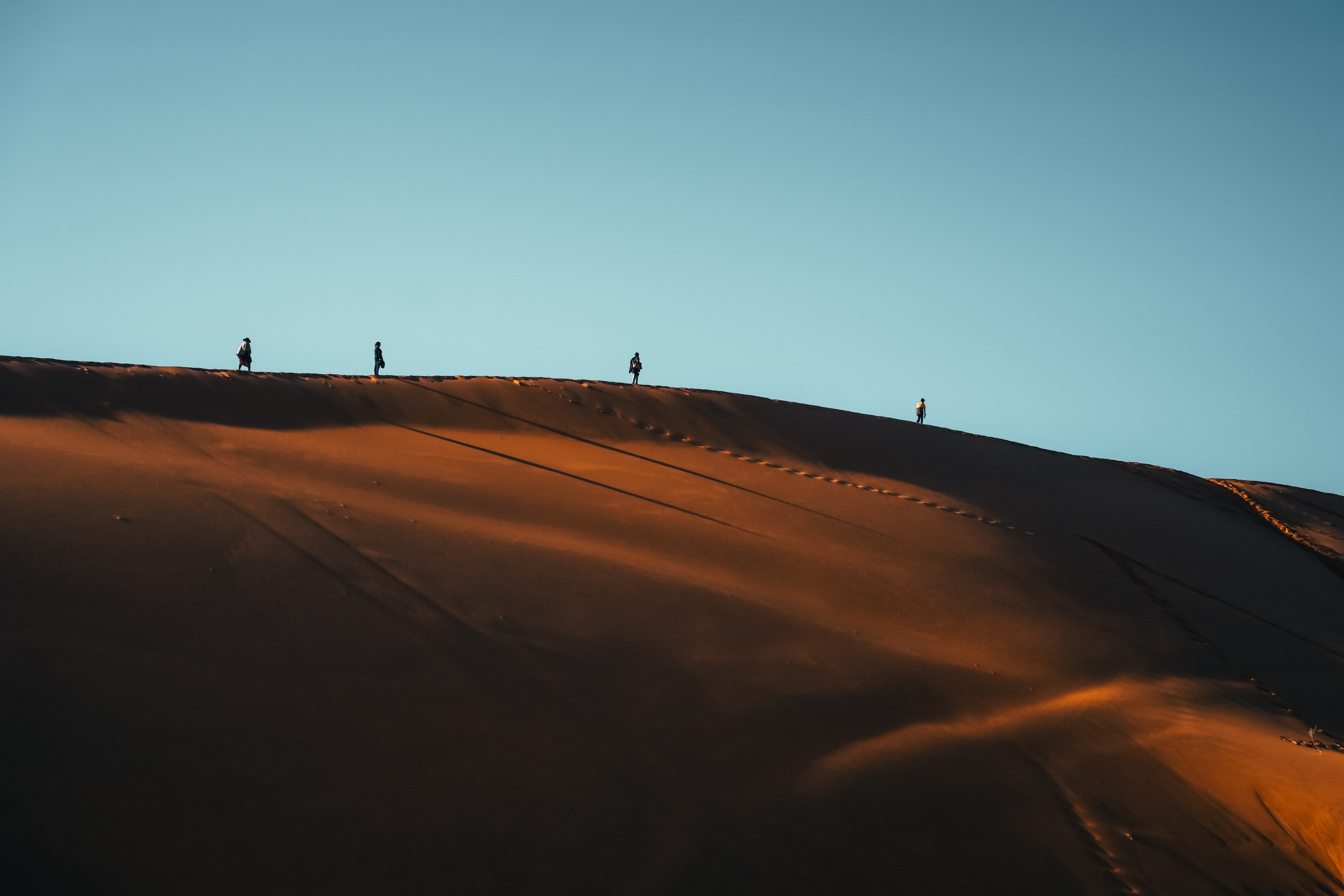 Silhouette tourist walking on Namibia Desert Dune
