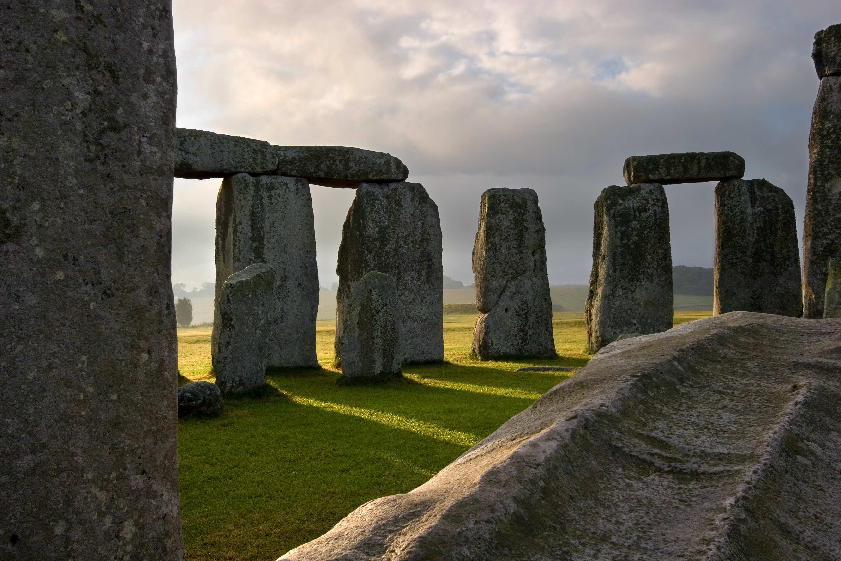 The sun rises, shedding it's rays through the massive hand carved stones at Stonehenge built on the Salisbury plains thousands of years ago