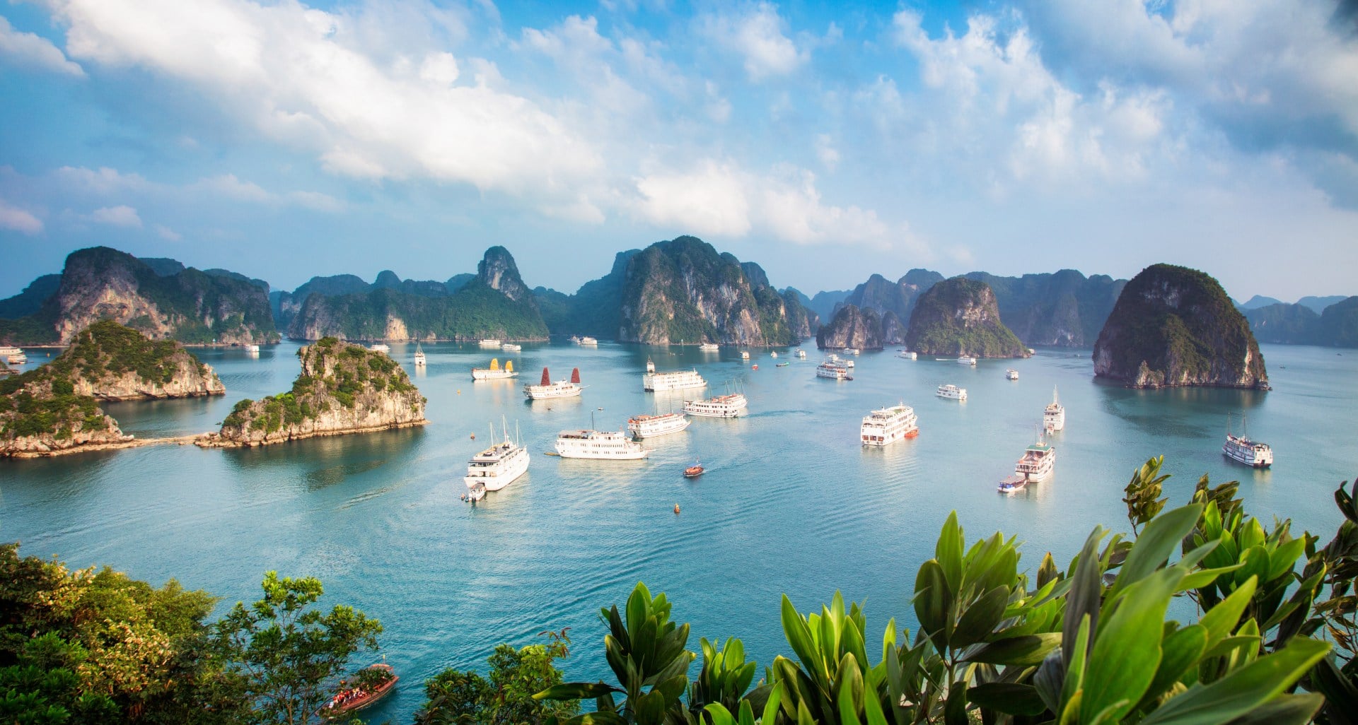 Halong Bay Vietnam panorama at sunset with anchored tourist ships