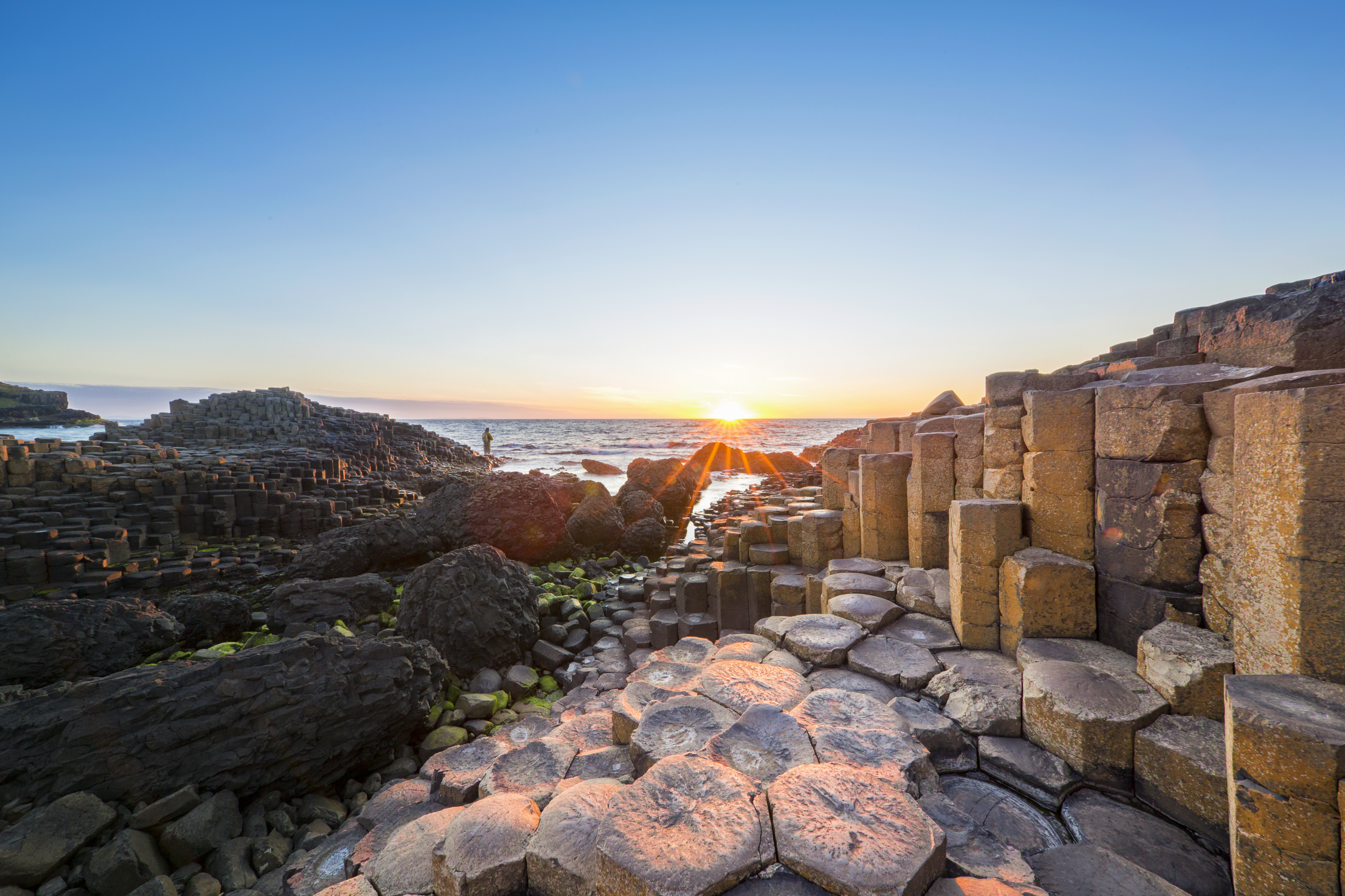 Tourist on basalt column at Giants Causeway