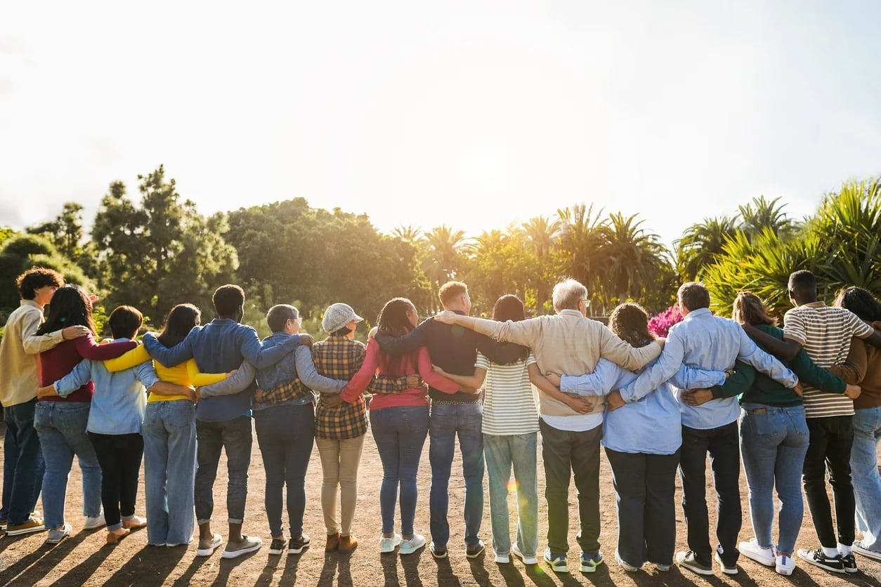 A group of employees stand with arms joined