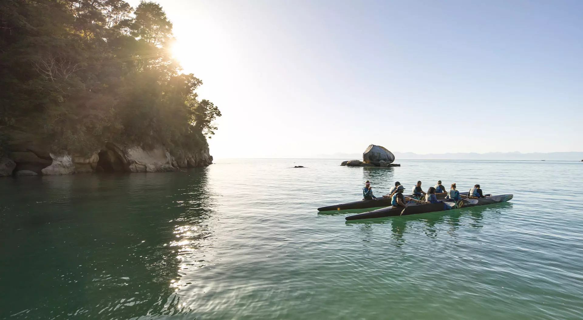 A sea kayak passes through the waters of Abel Tasman National Park in New Zealand.