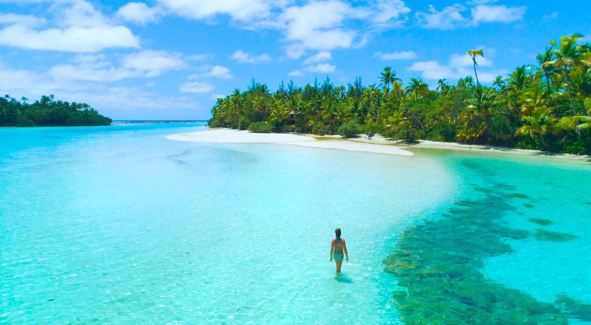One Foot Island, Cook Islands A woman walks through the surf in the clear lagoon of One Foot Island off Aitutaki in the Cook Islands.