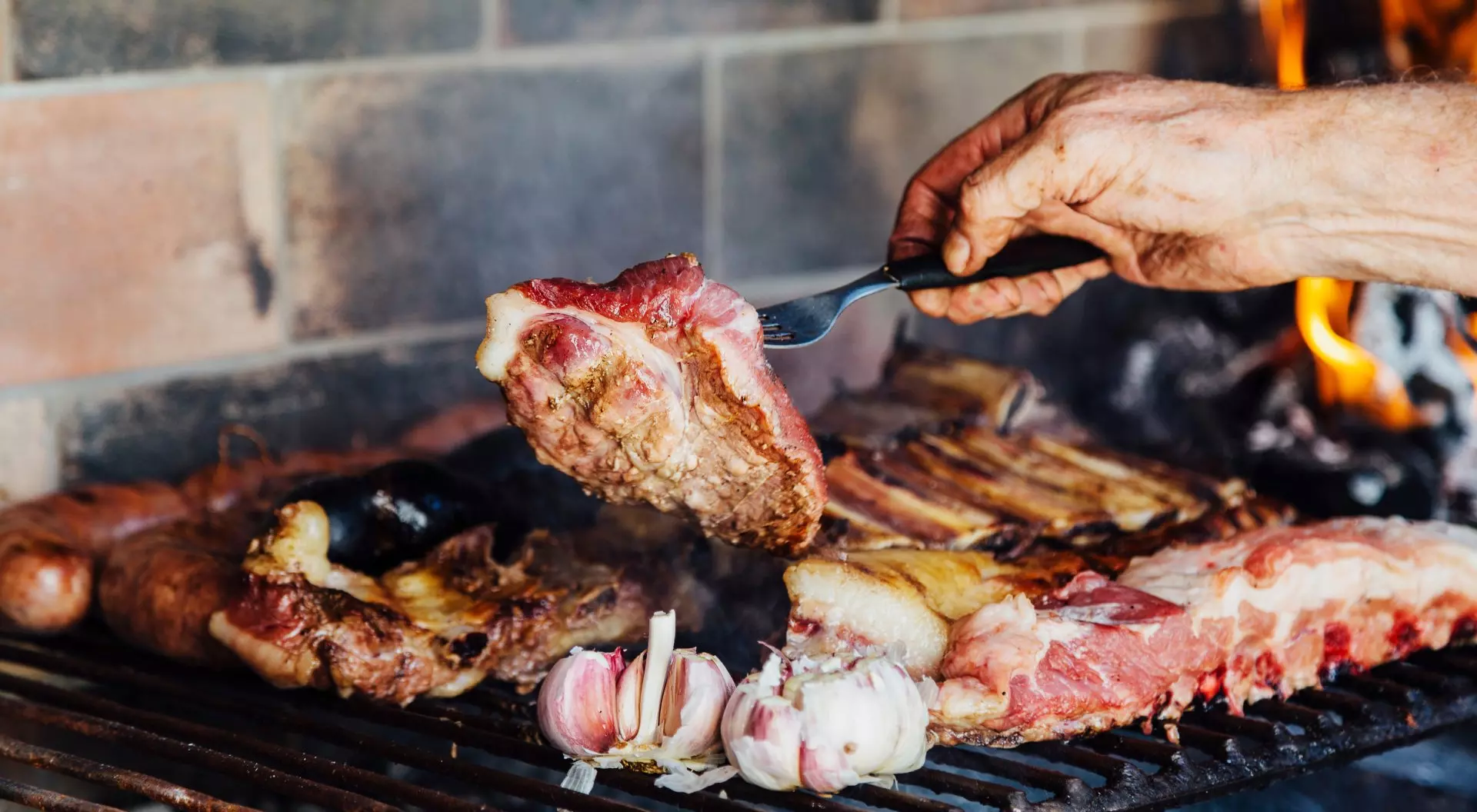 Argentinian meat roasting on the grill. Man making a traditional barbecue called Asado in Argentina.