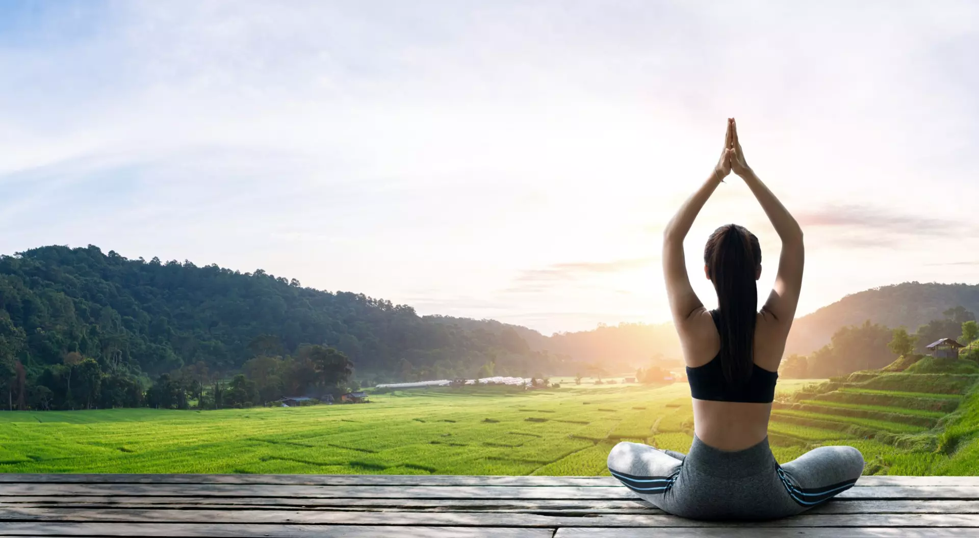 Asian woman doing yoga on the wooden balcony