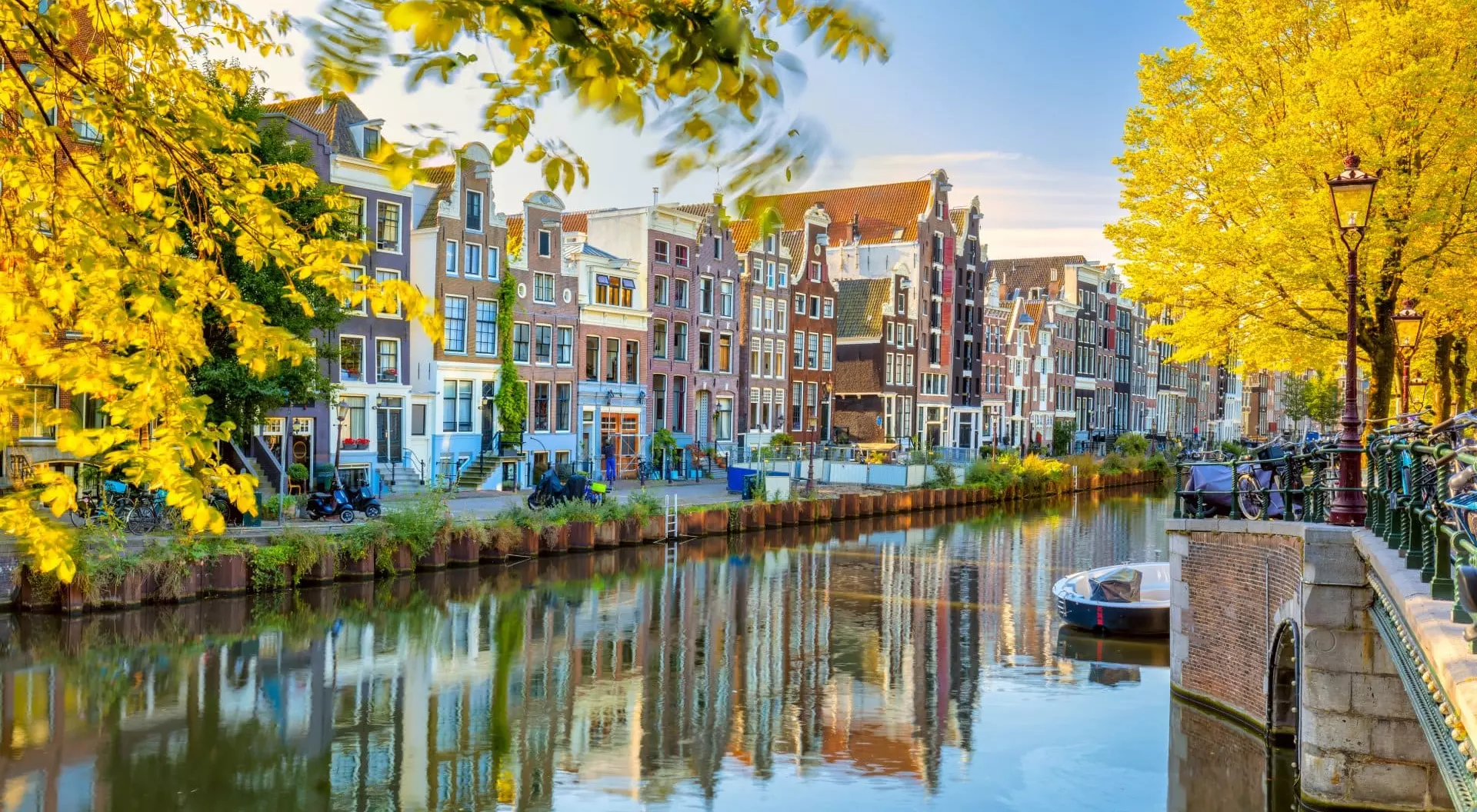 Autumn morning in Amsterdam. Silence. Ancient houses are reflected in the water of the canal, the sun shines through the trees. Lovely morning in Amsterdam