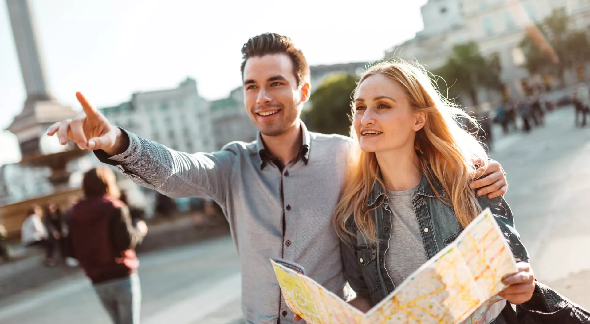 Couple Reading Map at Trafalgar Square in London, England, UK 