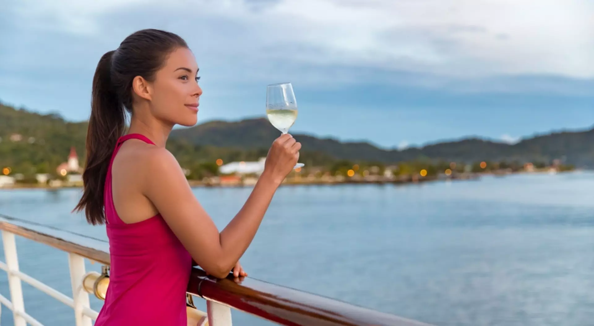 Elegant woman drinking glass of champagne on luxury cruise vacation