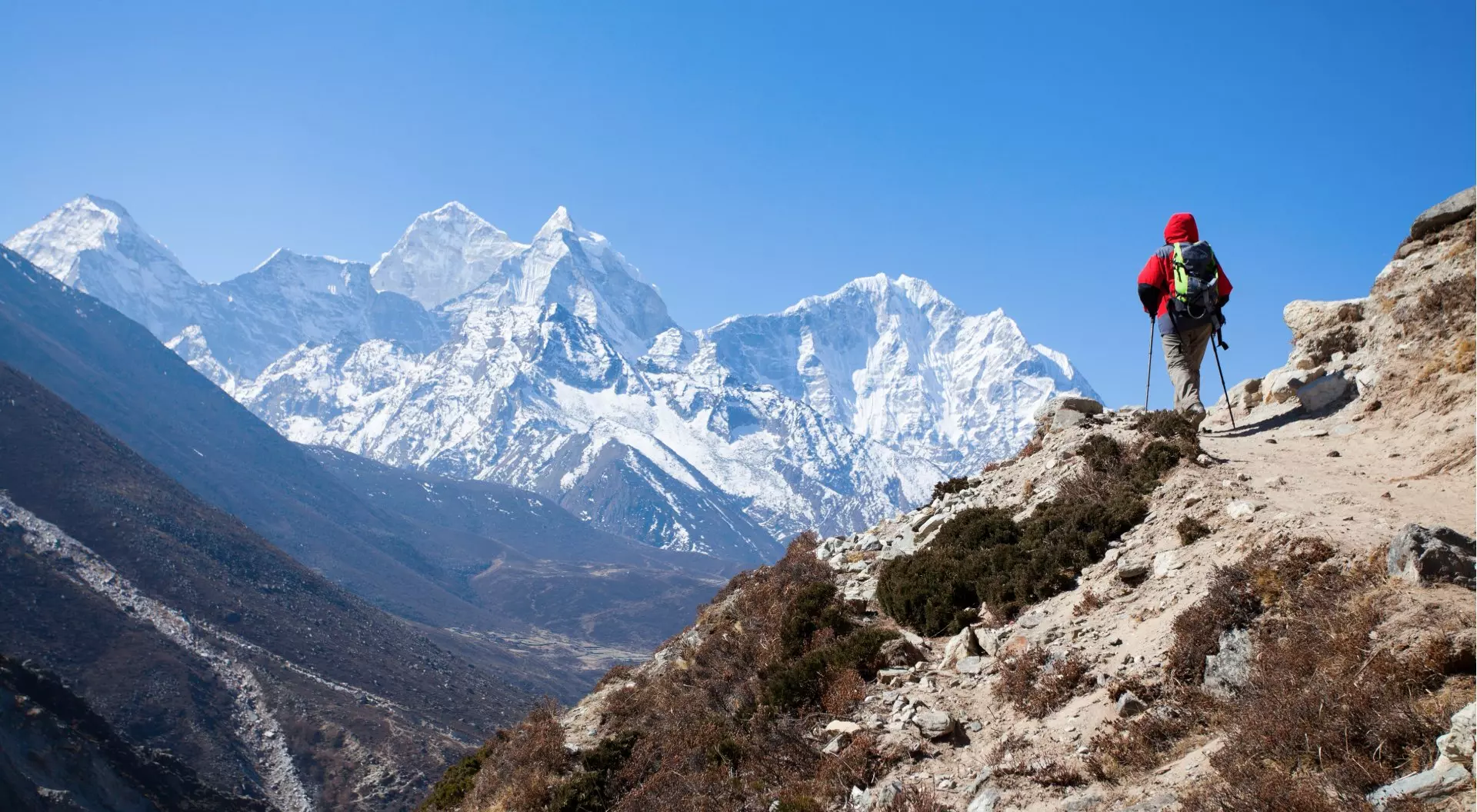 Hiker walking on the treek towards the majestic mountain peaks of the Himalayas