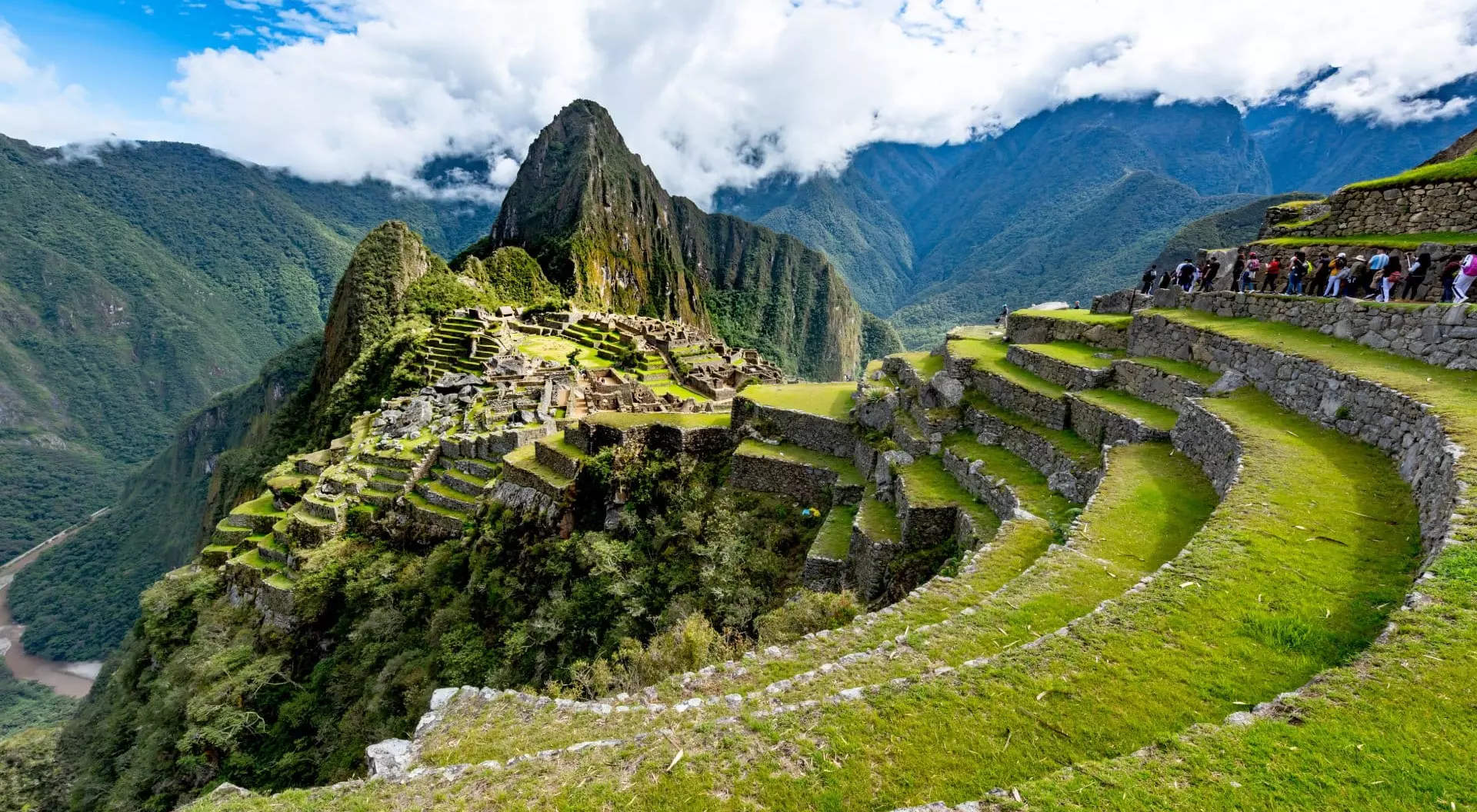 Machu Picchu aerial view. Tourists are walking through the old abandoned city.