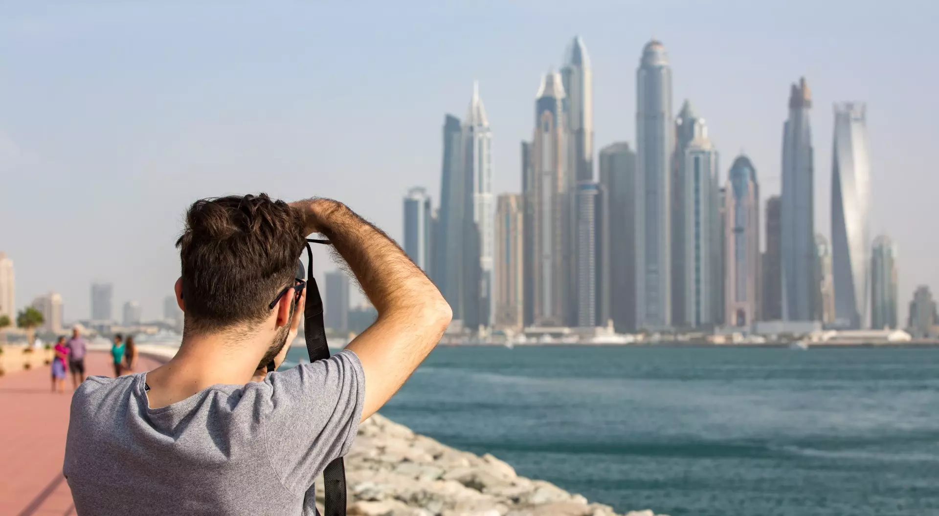 Dubai Marina, Dubai, United Arab Emirates Male Tourist taking photo of the Dubai Marina skyline, United Arab Emirates (UAE)
