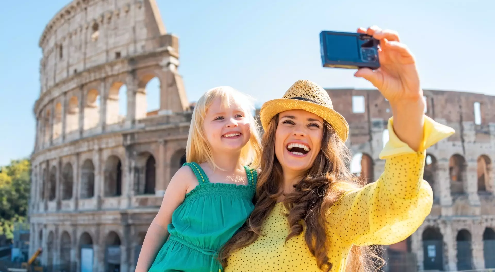 Mother and baby girl taking selfie in front of Colosseum in Rome, Italy