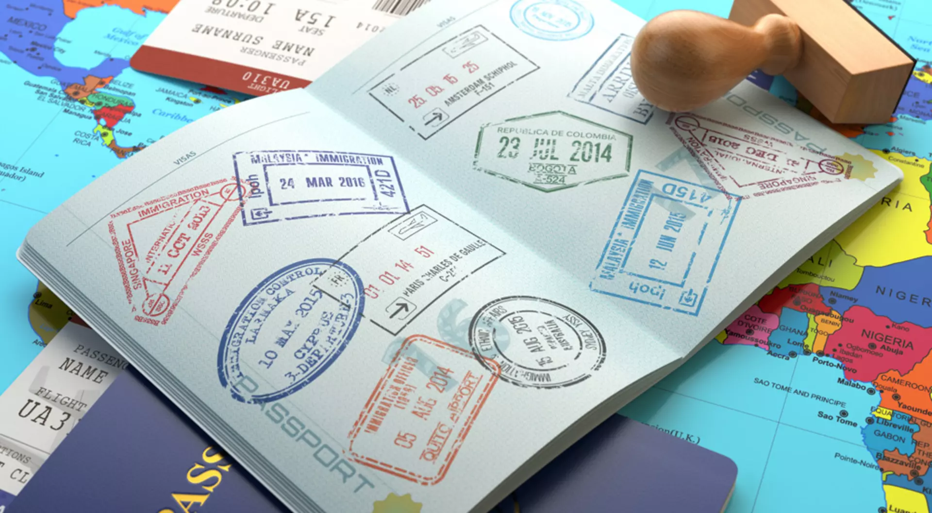 Opened passport with stamps, airline boarding pass tickets and stamper on world map