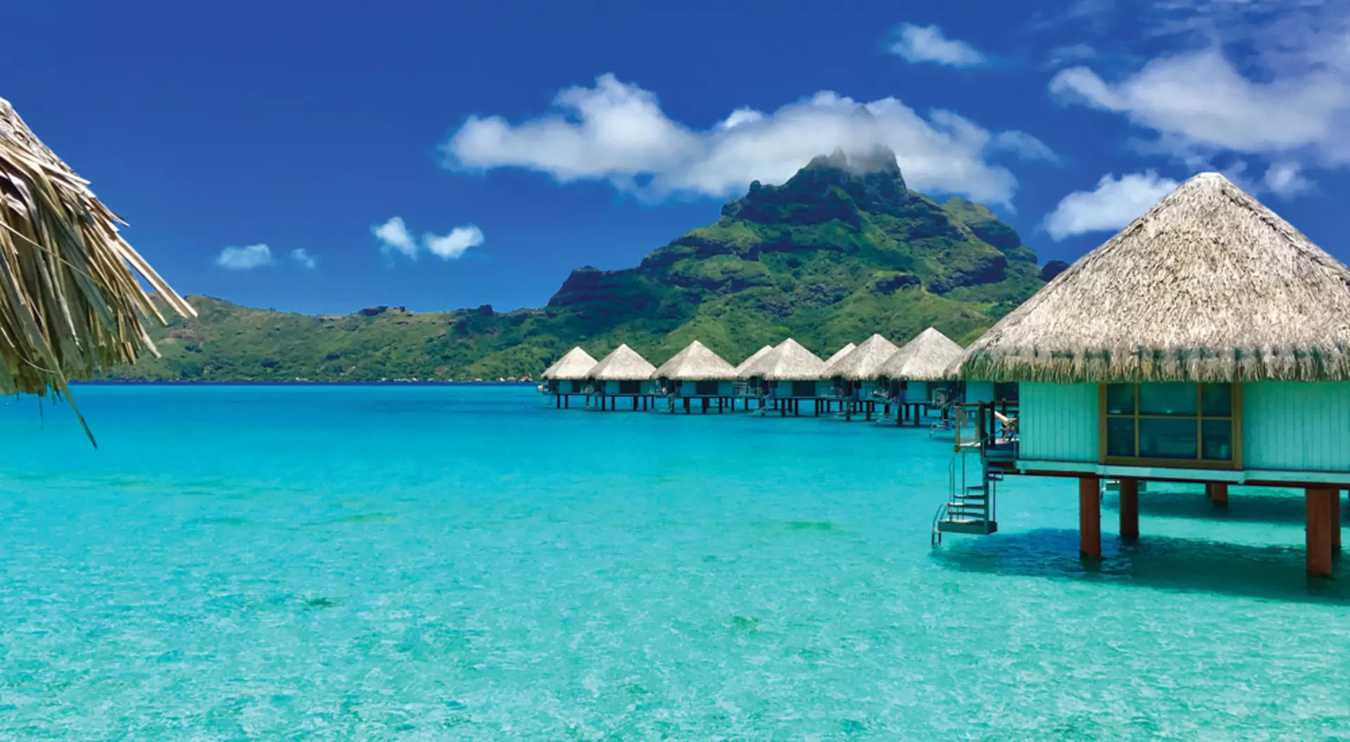 Overwater bungalows of a luxury resort providing a view of the Otemanu, Bora Bora, Tahiti, French Polynesia