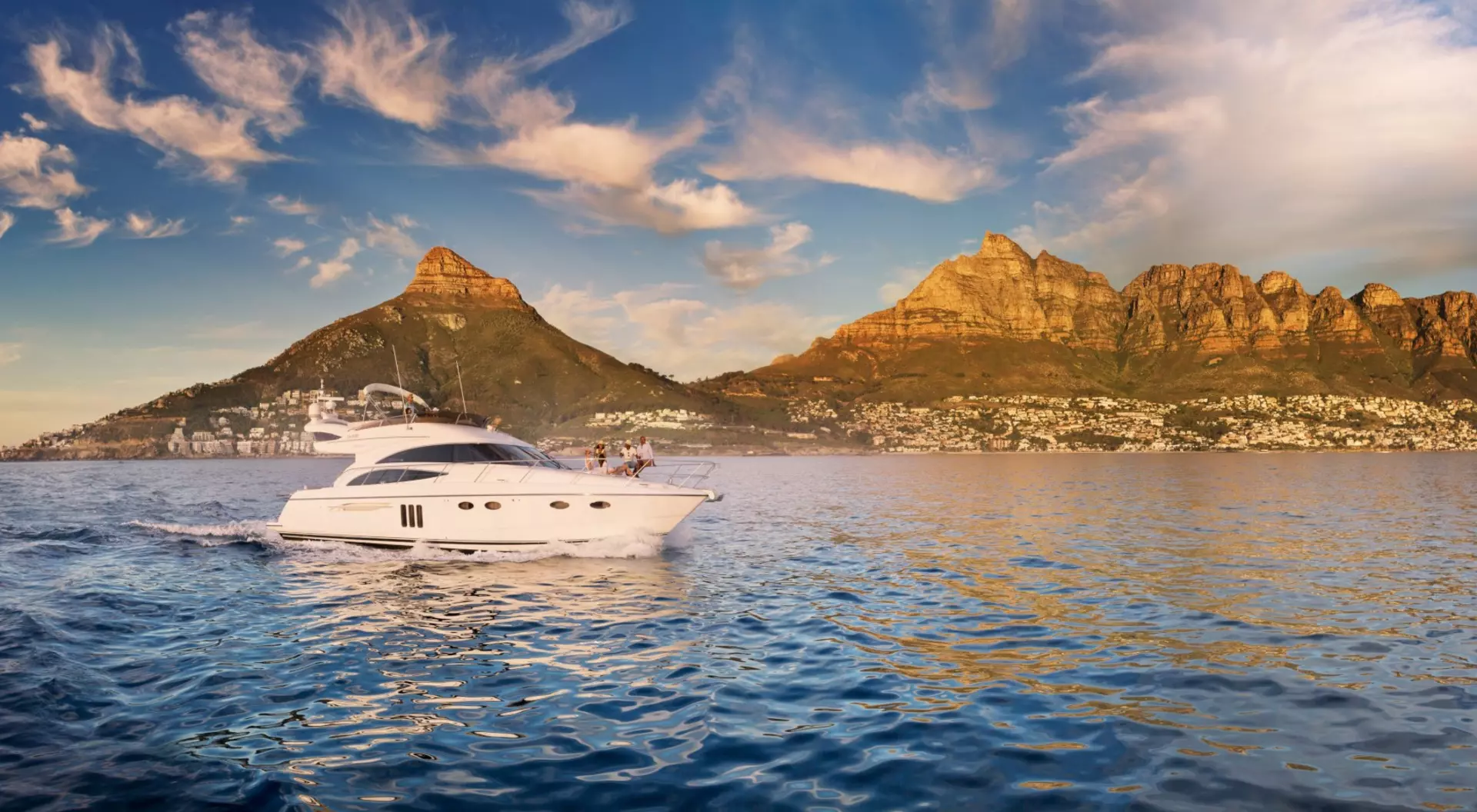 A yacht cruises along the coast near the Twelve Apostles in Camps Bay in South Africa's Western Cape.