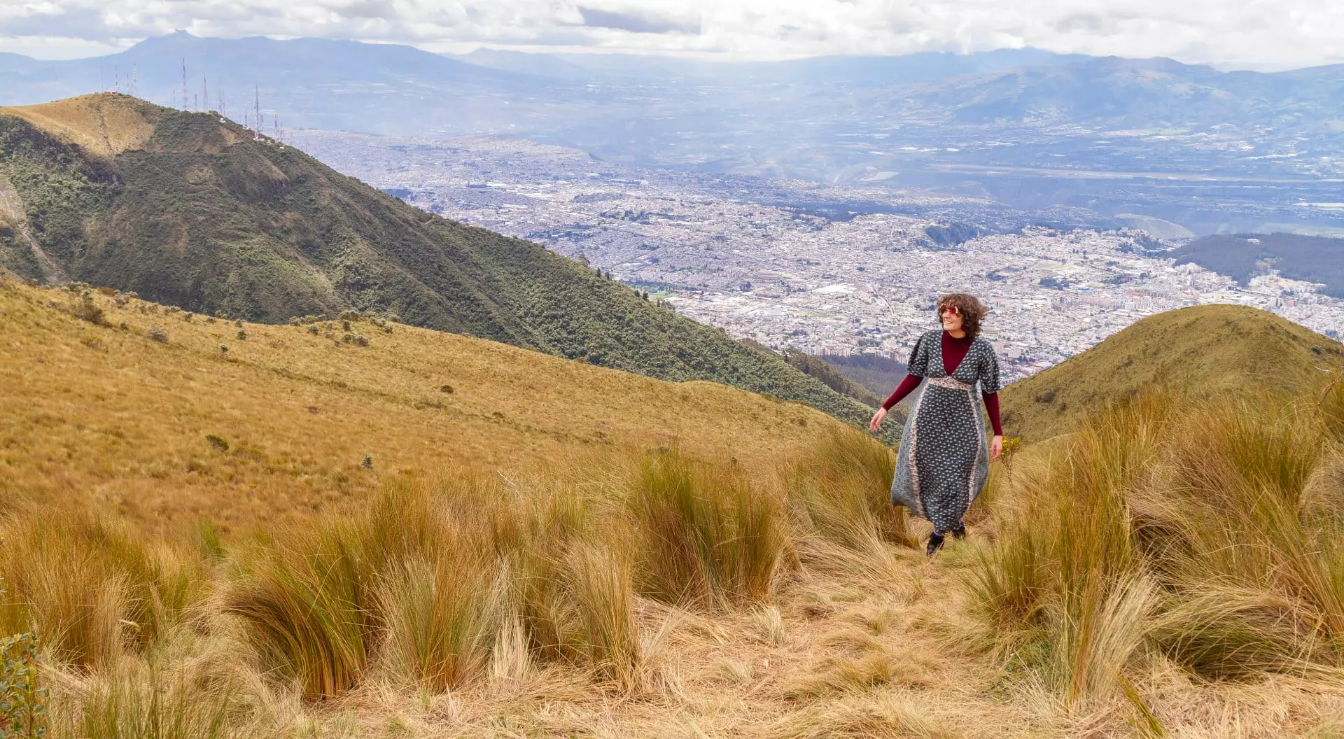 Quito, Ecuador Portrait of young teenager solo traveler female walking to the top of the Pichincha's volcano mountain. On Back, the ecuatorian capital: Quito. Carefree backpacker fashion woman, in Quito, Pichincha, Ecuador
