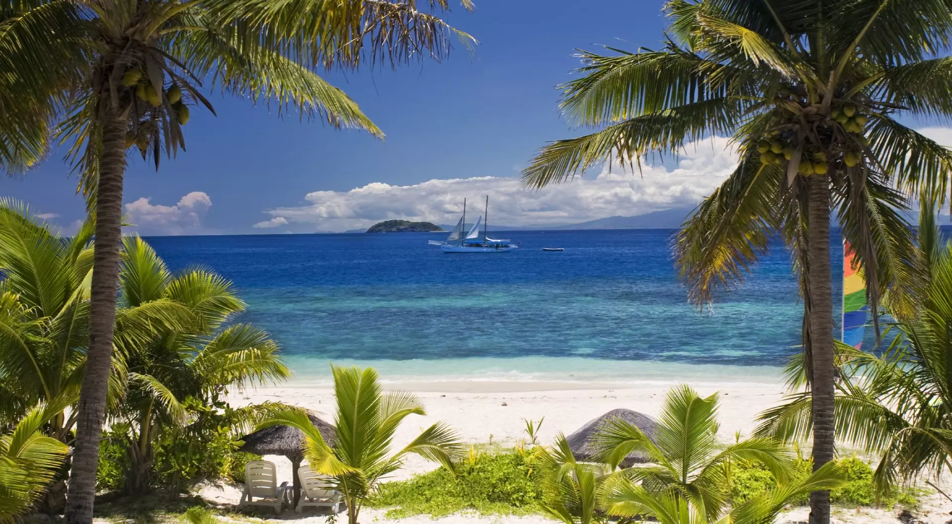 Sail boat seen through palm trees, Mamanuca Group islands, Fiji