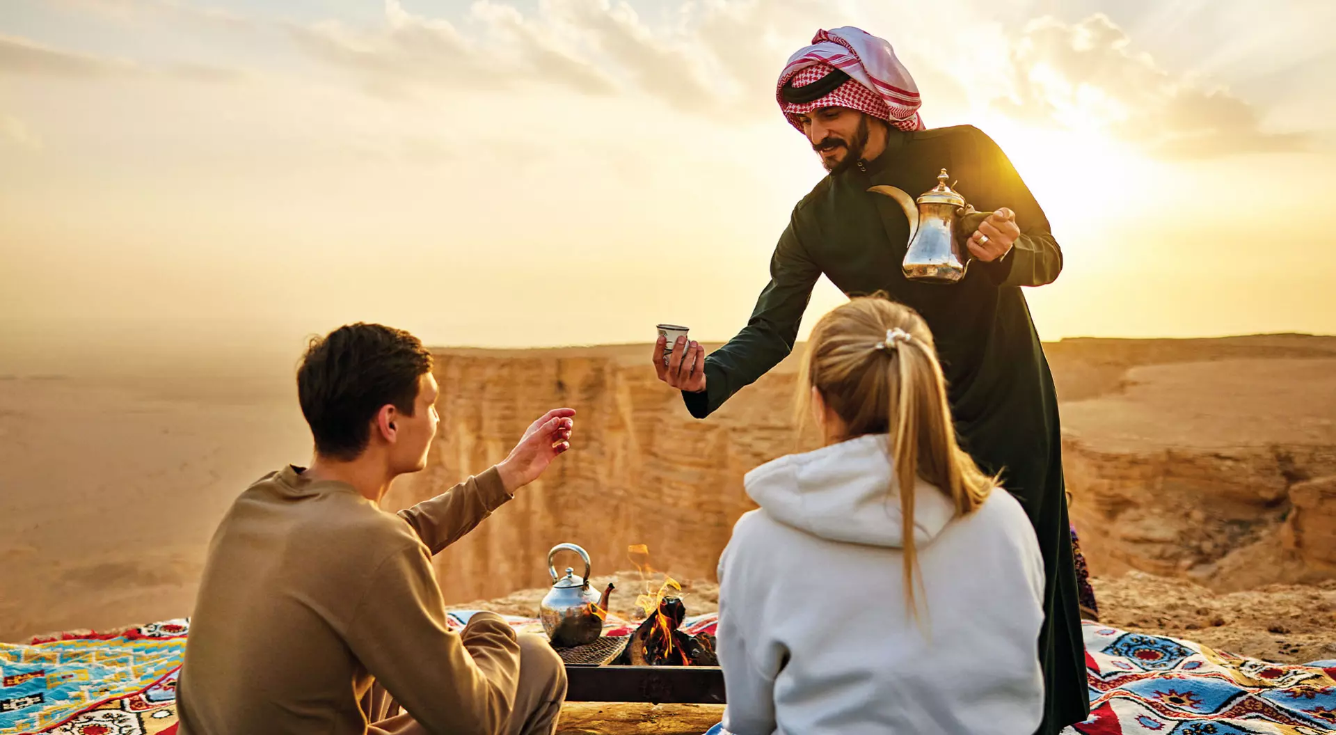 The Edge of the World, Saudi Arabia A Saudi guide serves traditional tea to western travellers at the Edge of the World in Riyadh, Saudi Arabia