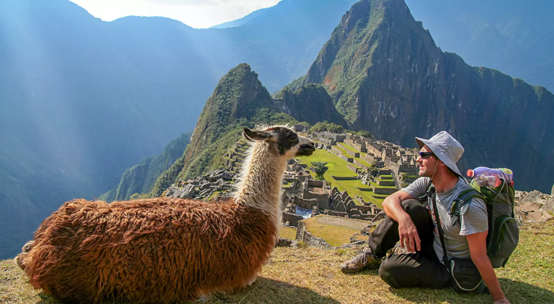 Machu Picchu, Peru Tourist and Llama sitting in front of Machu Picchu, Peru